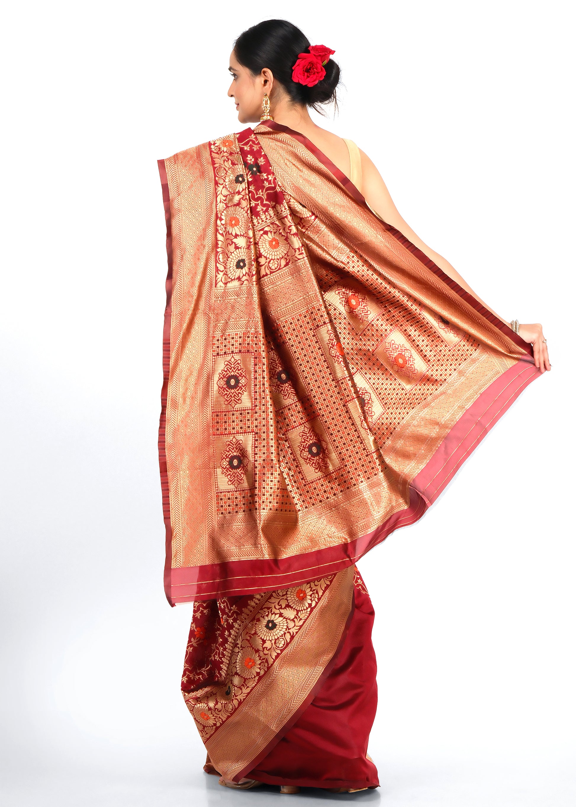 Back view of a woman draped in a rich red Banarasi saree, highlighting the stunning golden zari work on the pallu.