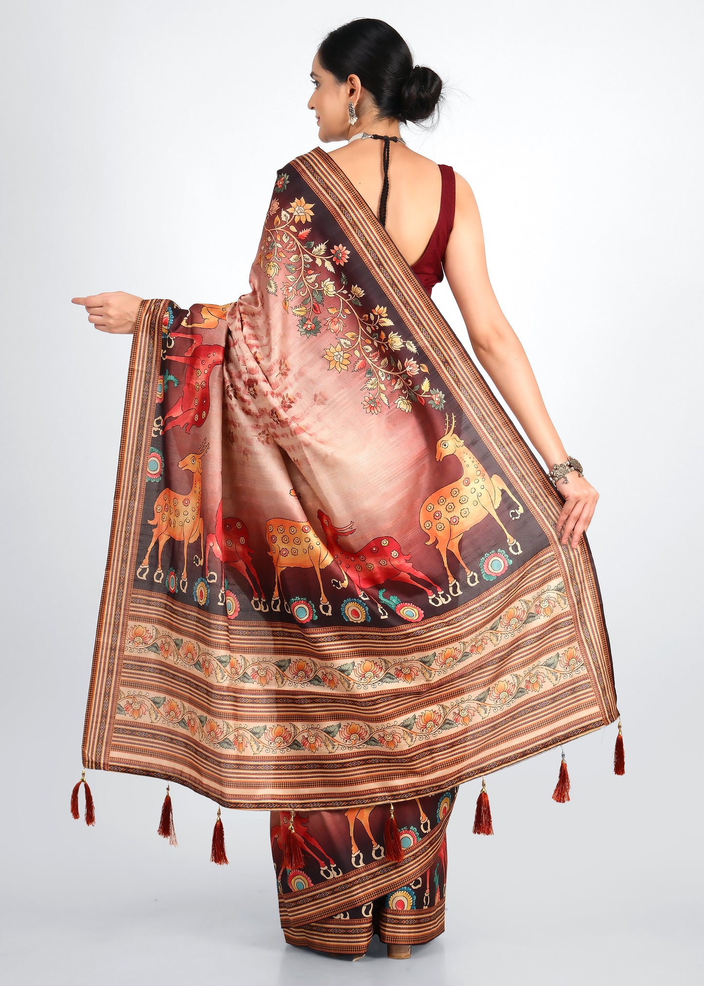 Back view of a beige saree featuring intricate animal motifs and floral patterns on the pallu