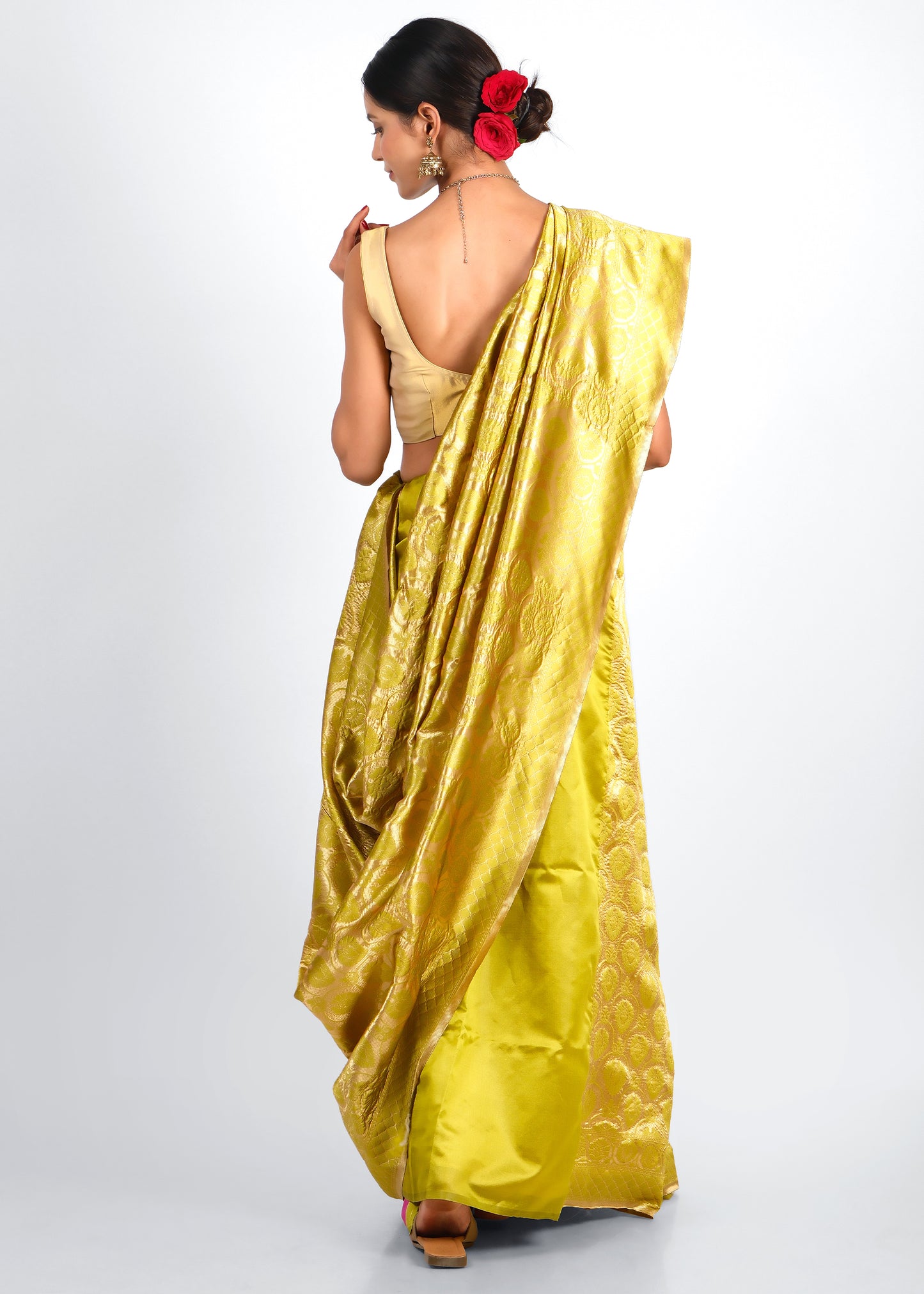 Rear view of a stunning yellow Banarasi silk saree with detailed gold weaving and traditional motifs