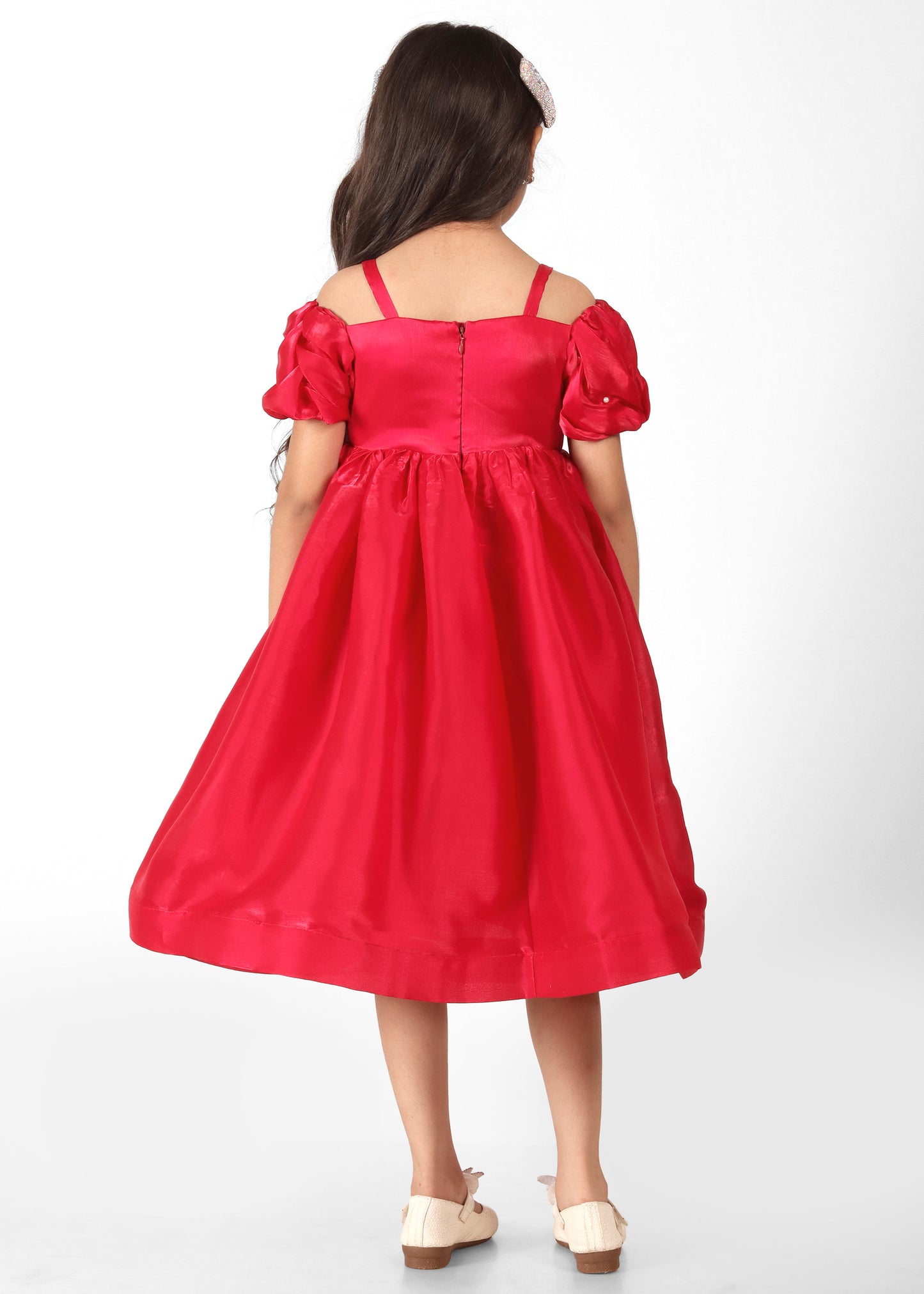 "Back view of a girl in a red satin dress with puff sleeves and zipper detailing, highlighting the full flow of the outfit."