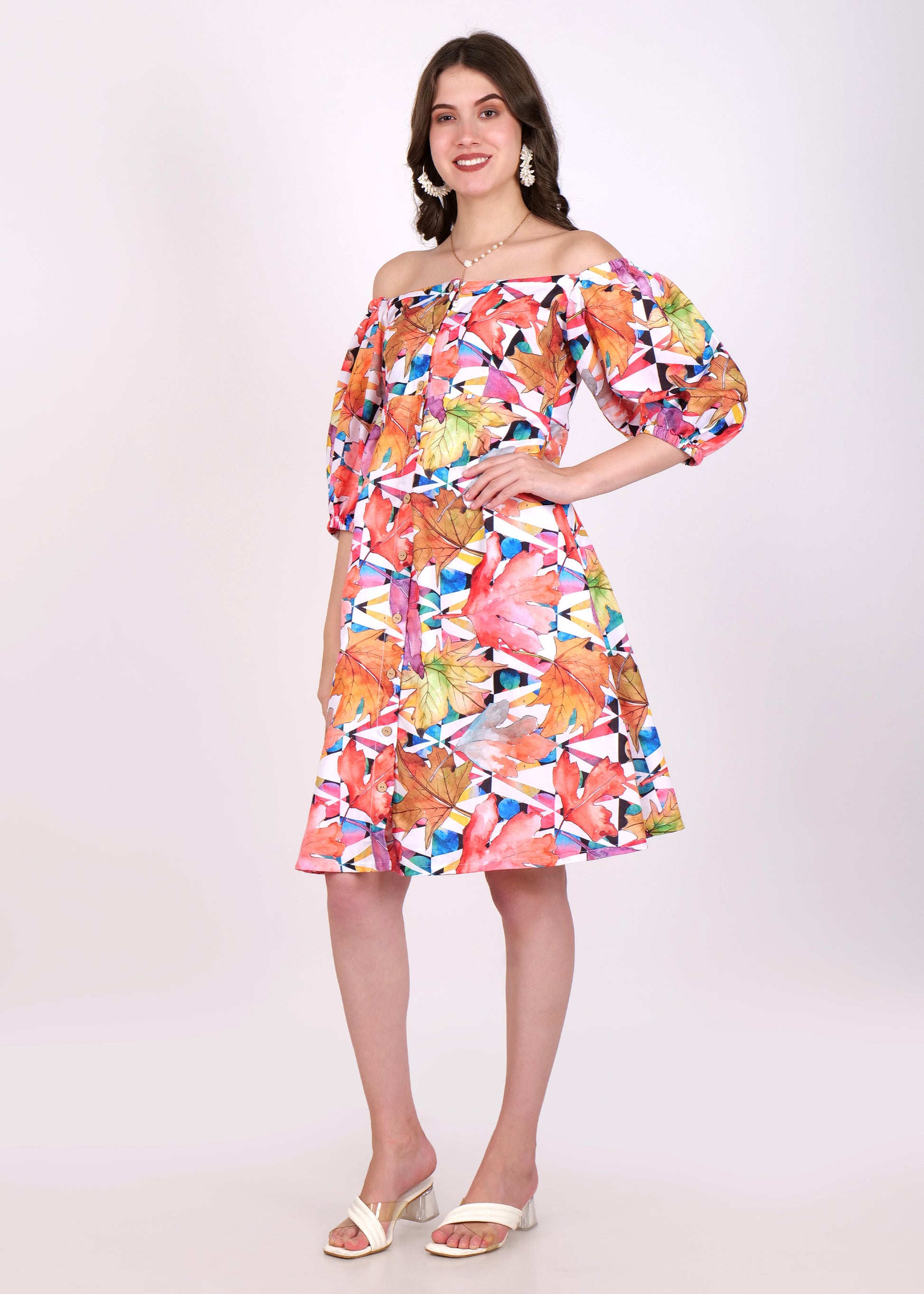 A side view of the same woman in the off-shoulder, floral leaf-print dress, showcasing the A-line silhouette and soft flow of the fabric