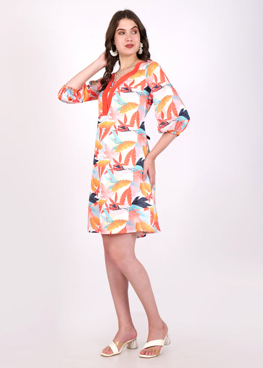 A woman wearing a colorful floral-print V-neck dress with a bold orange border. The dress has three-quarter sleeves and a flowing A-line cut