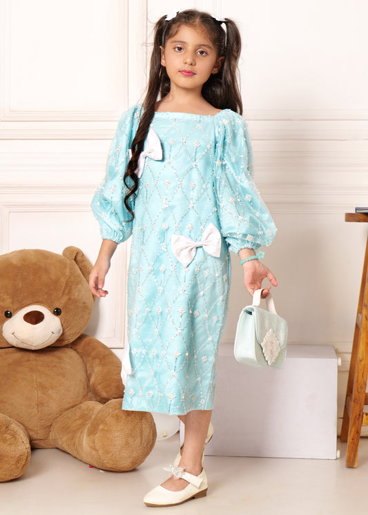 Young girl posing in an elegant light blue dress with intricate white embroidery and matching handbag, standing next to a large teddy bear