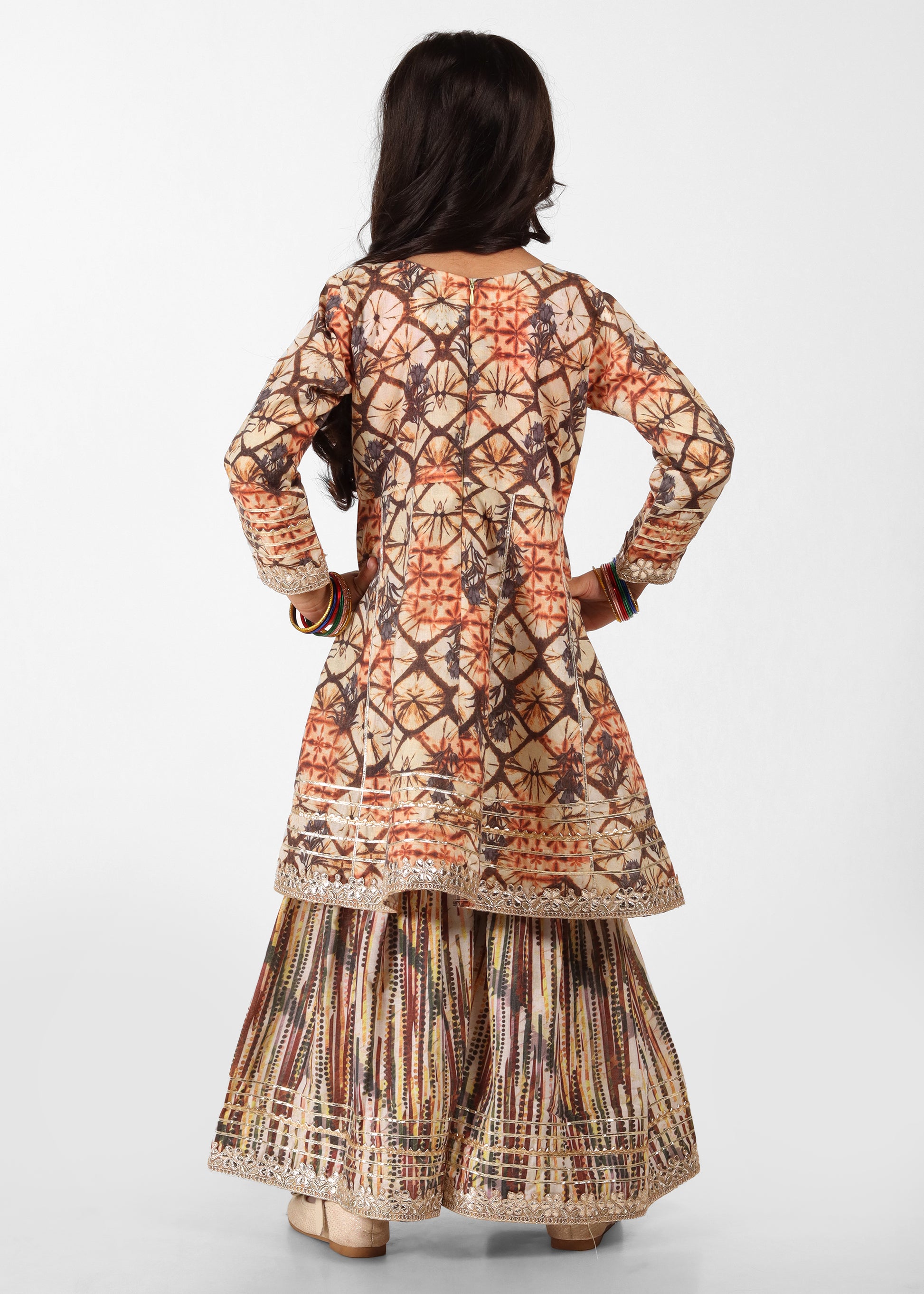 "Back view of a girl in a traditional lehenga with intricate designs, showcasing detailed fabric patterns and embroidery."