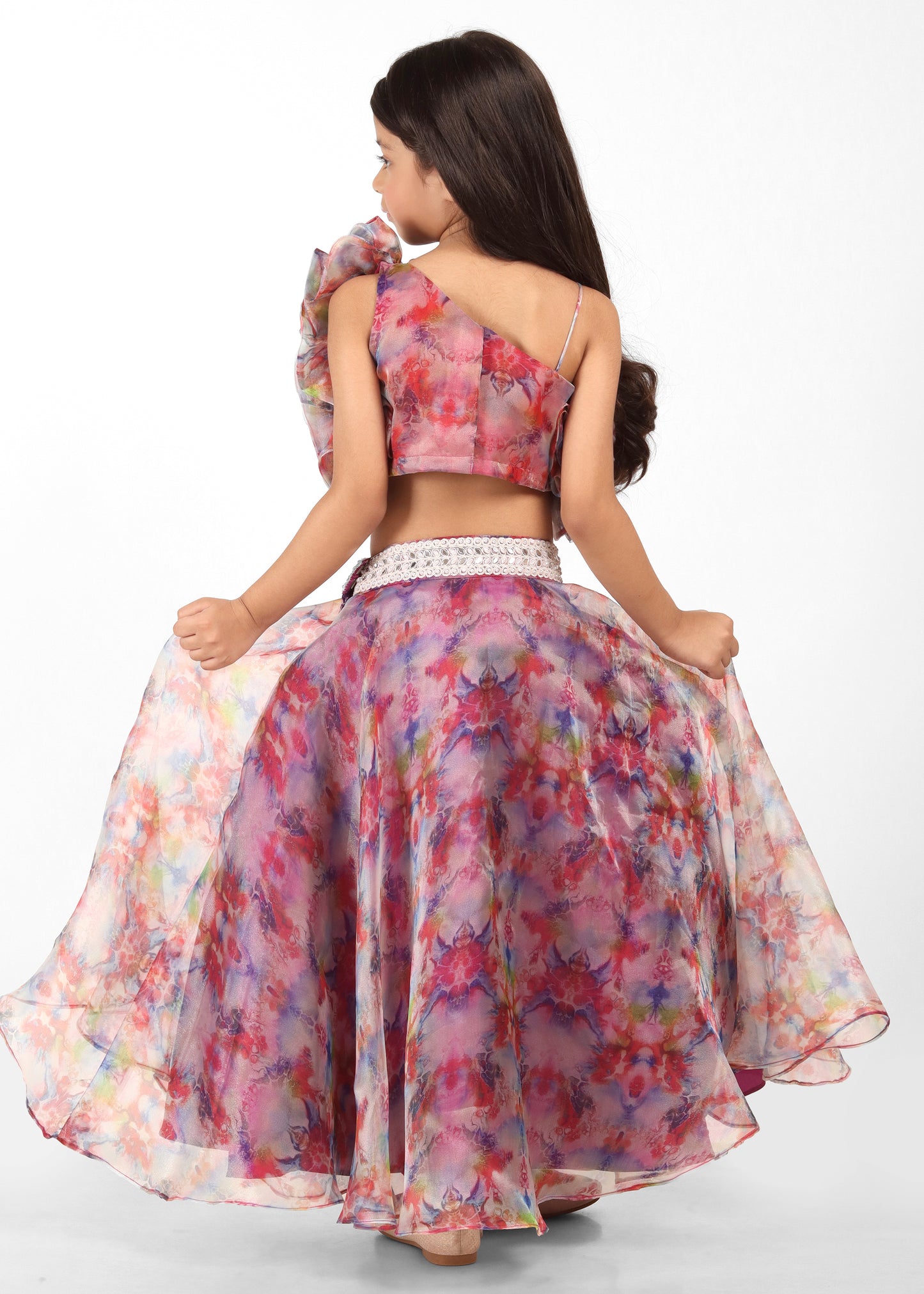 Rear view of a girl twirling in a floral lehenga, displaying the full design and movement of the skirt.