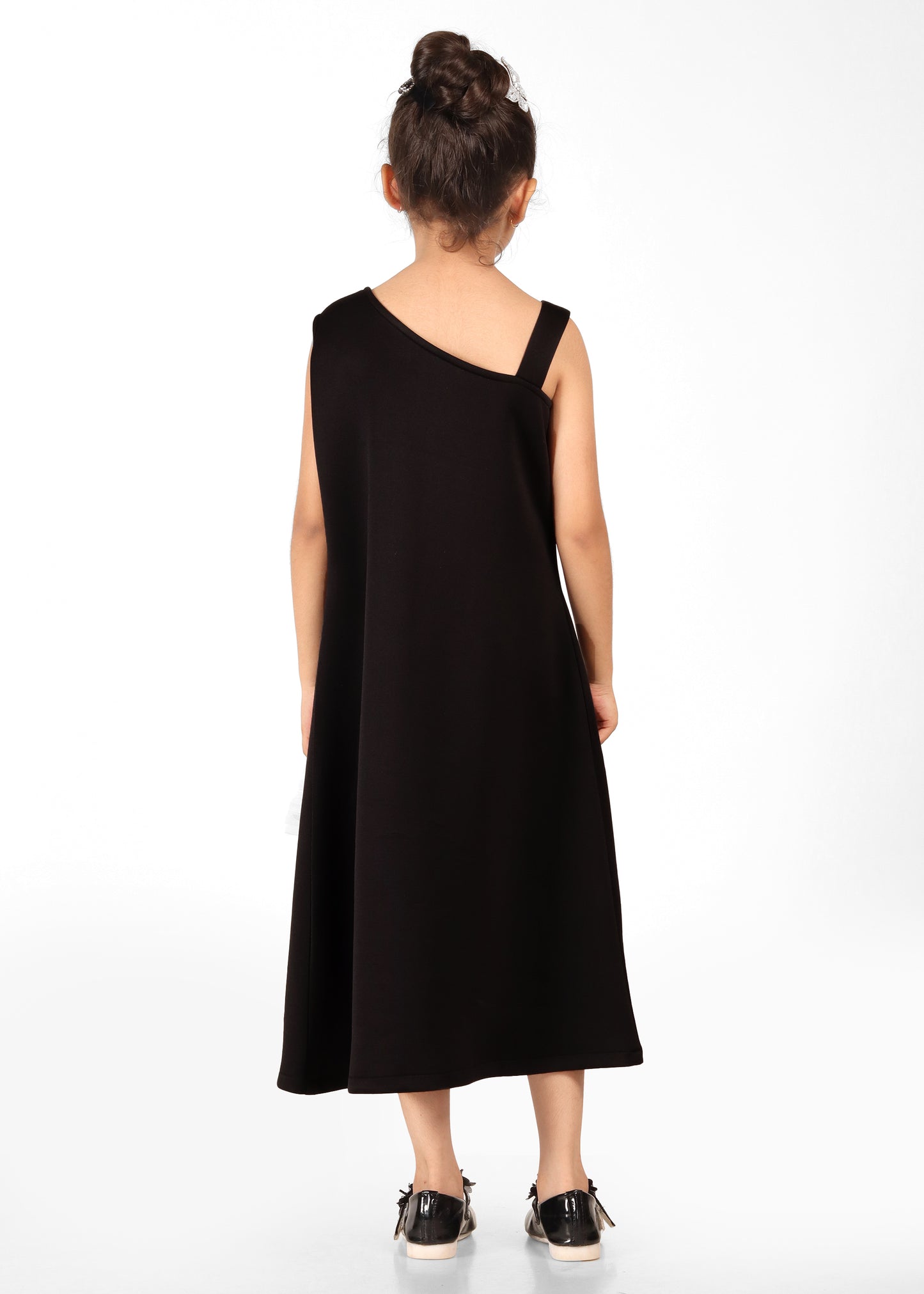 Rear view of a girl wearing a chic black one-shoulder dress with minimal design, displaying a sleek and modern fashion silhouette