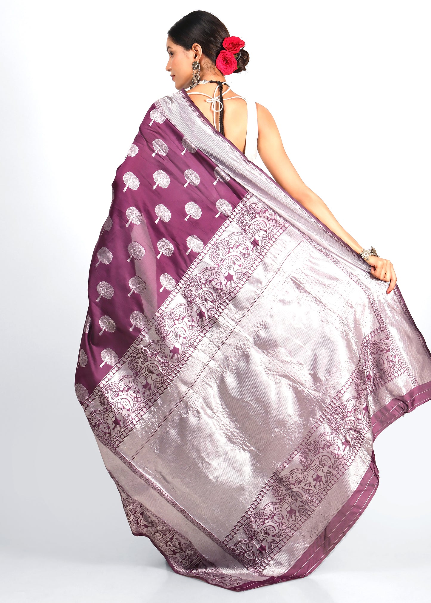 Back View of Purple Banarasi Silk Saree with Detailed Pallu Design
The back view of the purple Banarasi silk saree highlights its elaborately designed silver pallu featuring intricate elephant and floral motifs, draped elegantly by the model.