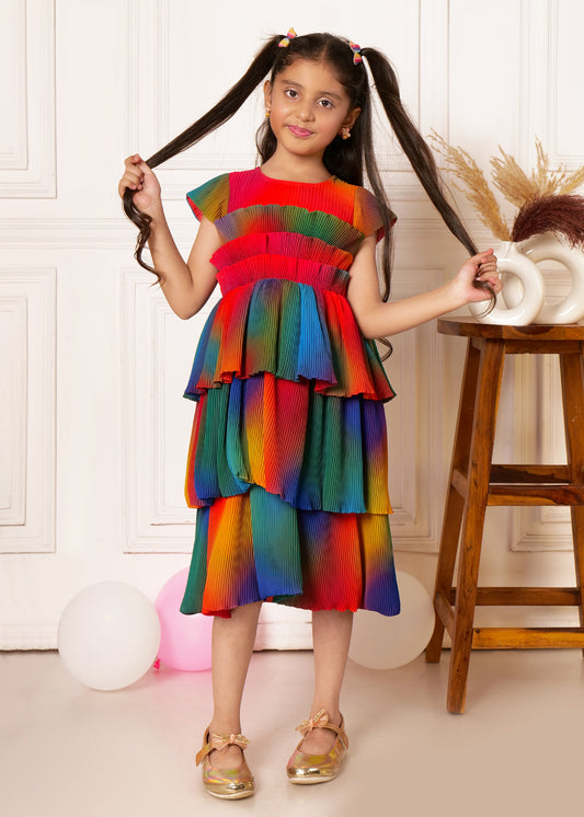 "Young girl in rainbow pleated dress, playful pose holding ponytails, girls fashion photography."