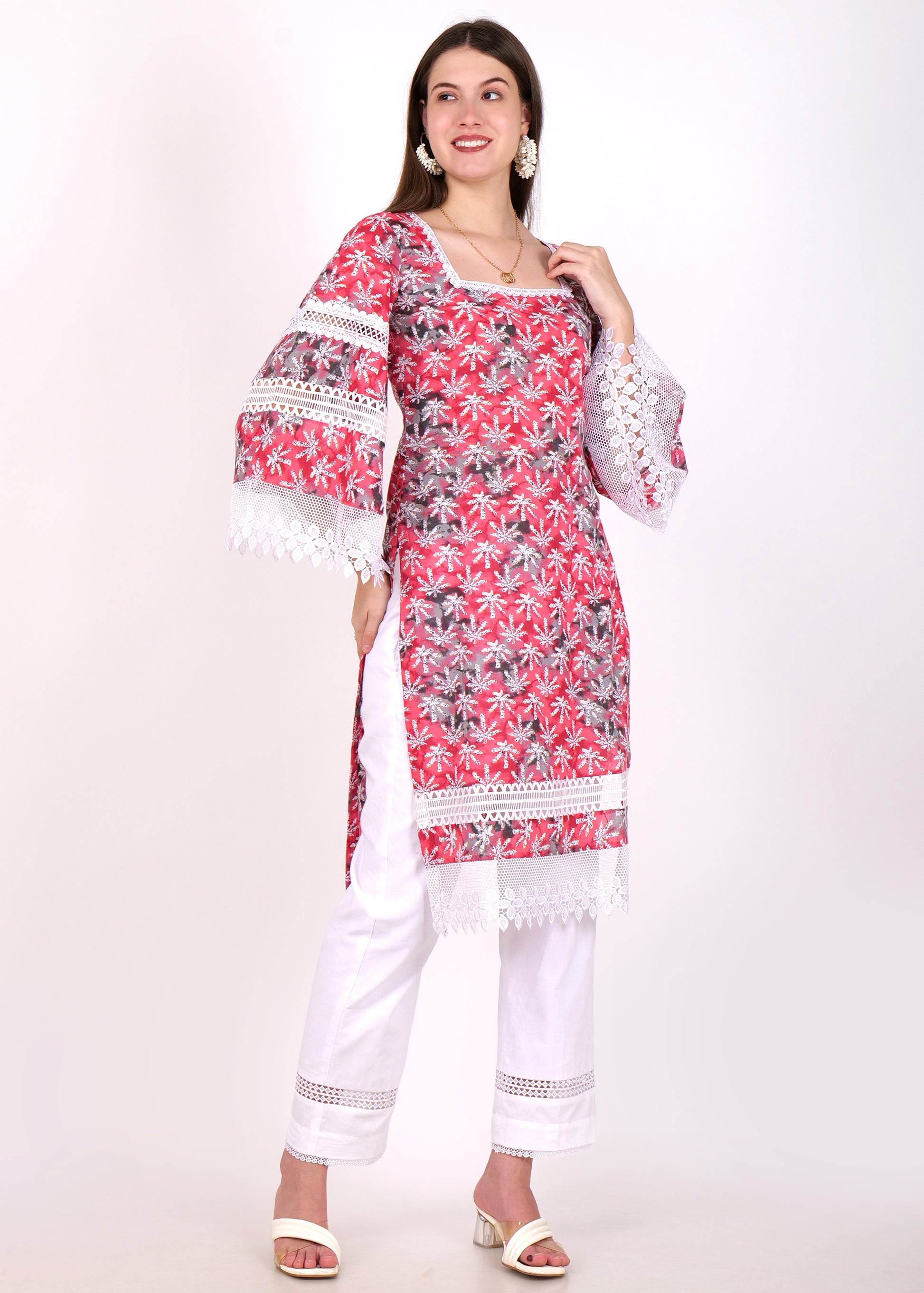 "Side view of floral red printed kurti with white lace borders, model styled with white straight pants"