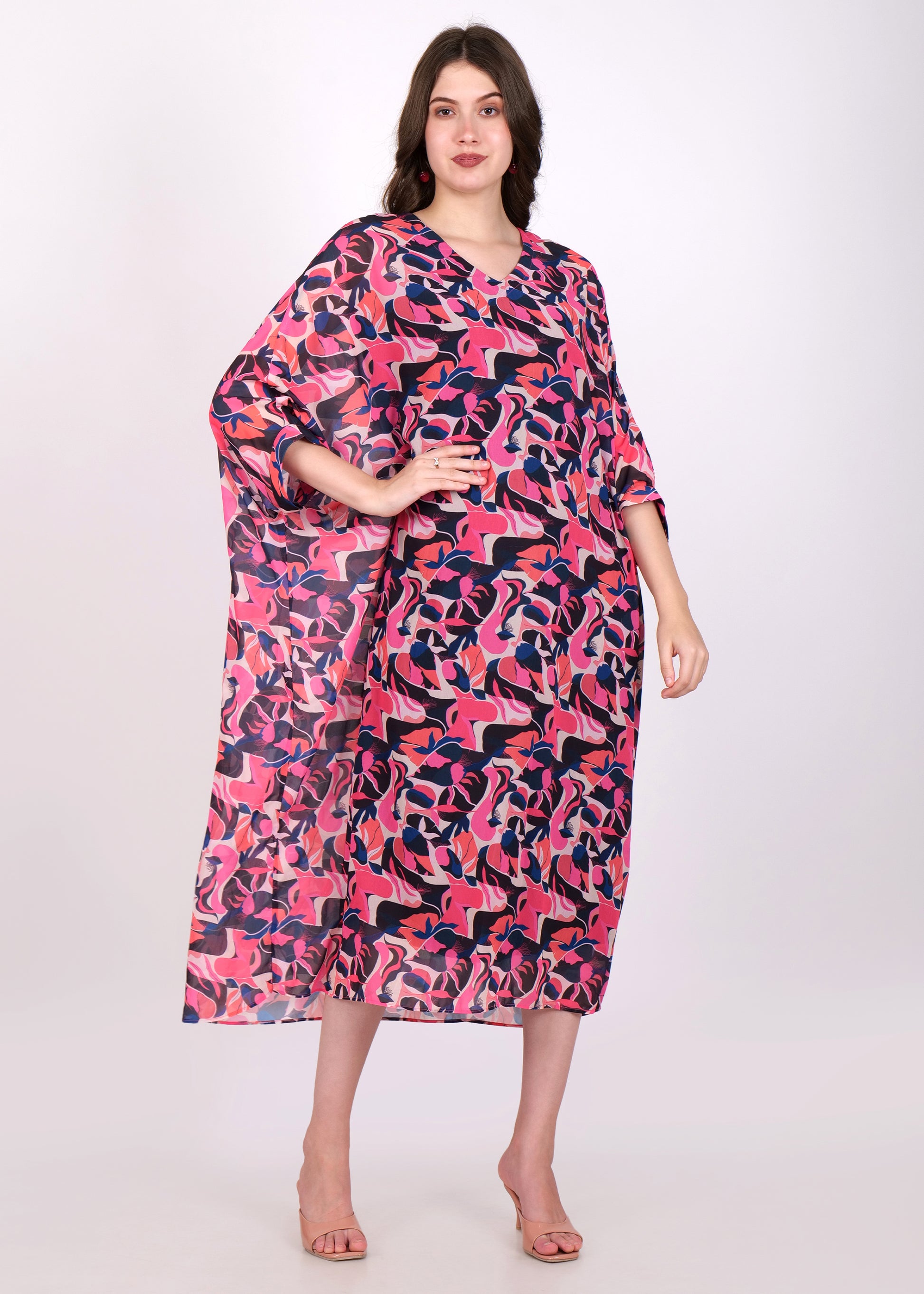 Front-facing view of the model in a pink and purple abstract kaftan dress, with a V-neck and a relaxed, flowy silhouette