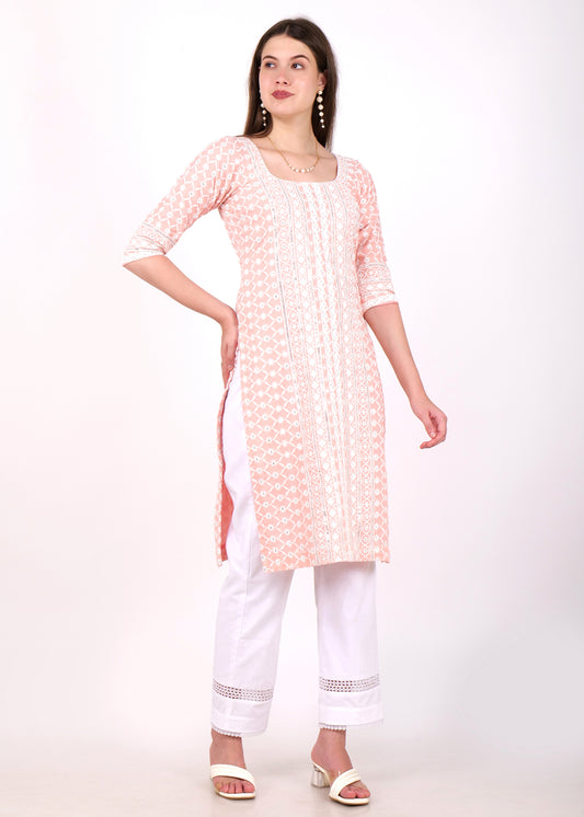 Front pose of model wearing a pastel pink cotton kurta with intricate white embroidery and lace detailing, paired with white trousers