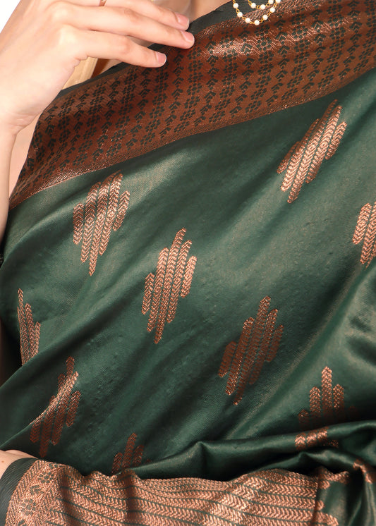 Close-up of a green and brown silk saree showing the gold zari work on the fabric