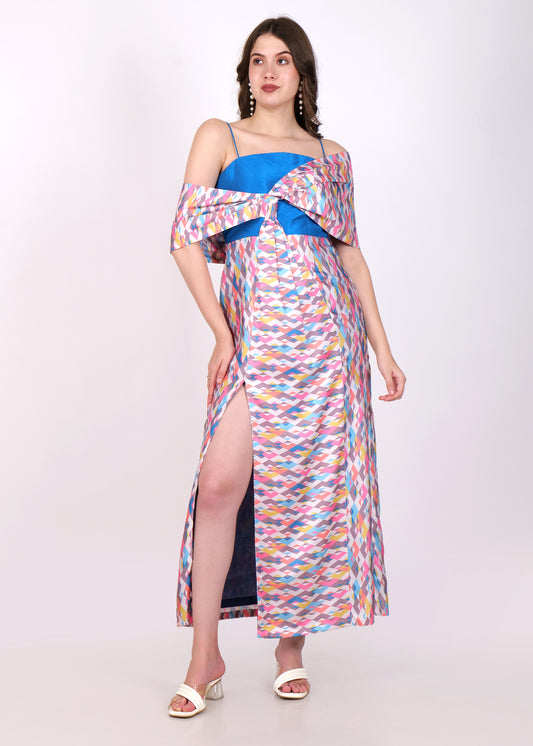 Front view of a model in a multicolored geometric print maxi dress with an off-shoulder design and high front slit