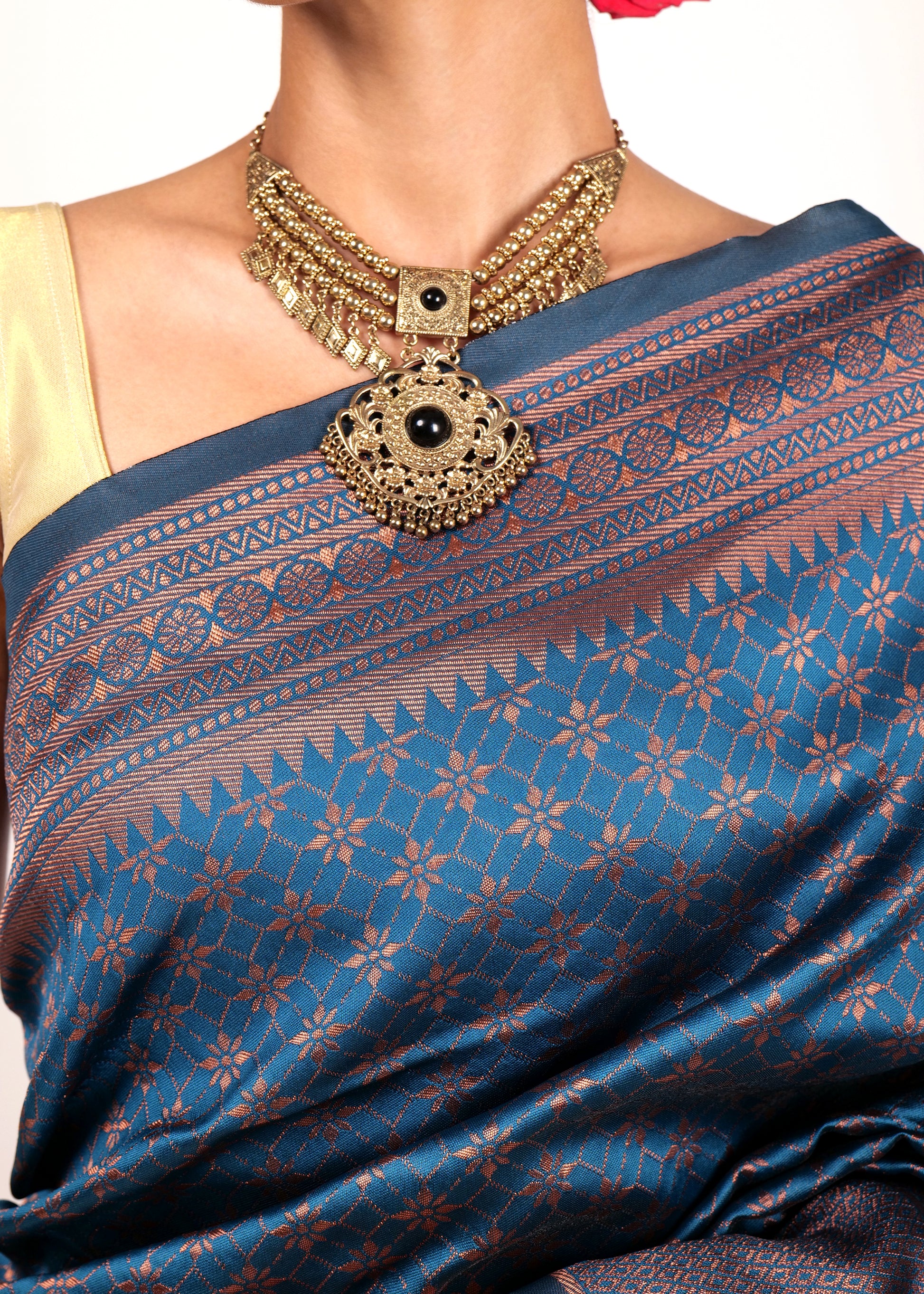 Close-up of navy blue Kanjivaram silk saree with detailed copper zari border and floral motifs