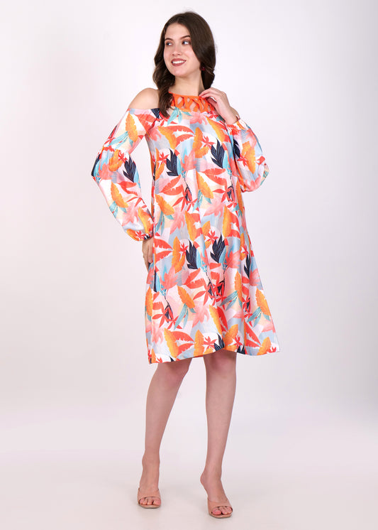 Front view of a model in a tropical leaf print dress with long sleeves, styled for a breezy summer look