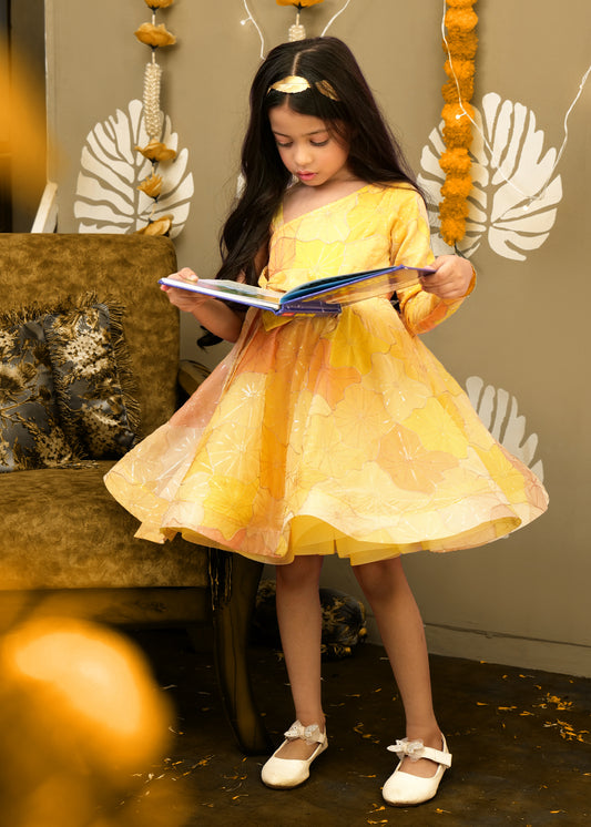 "Festive yellow one-shoulder dress with floral patterns, ideal for young girls at celebrations."