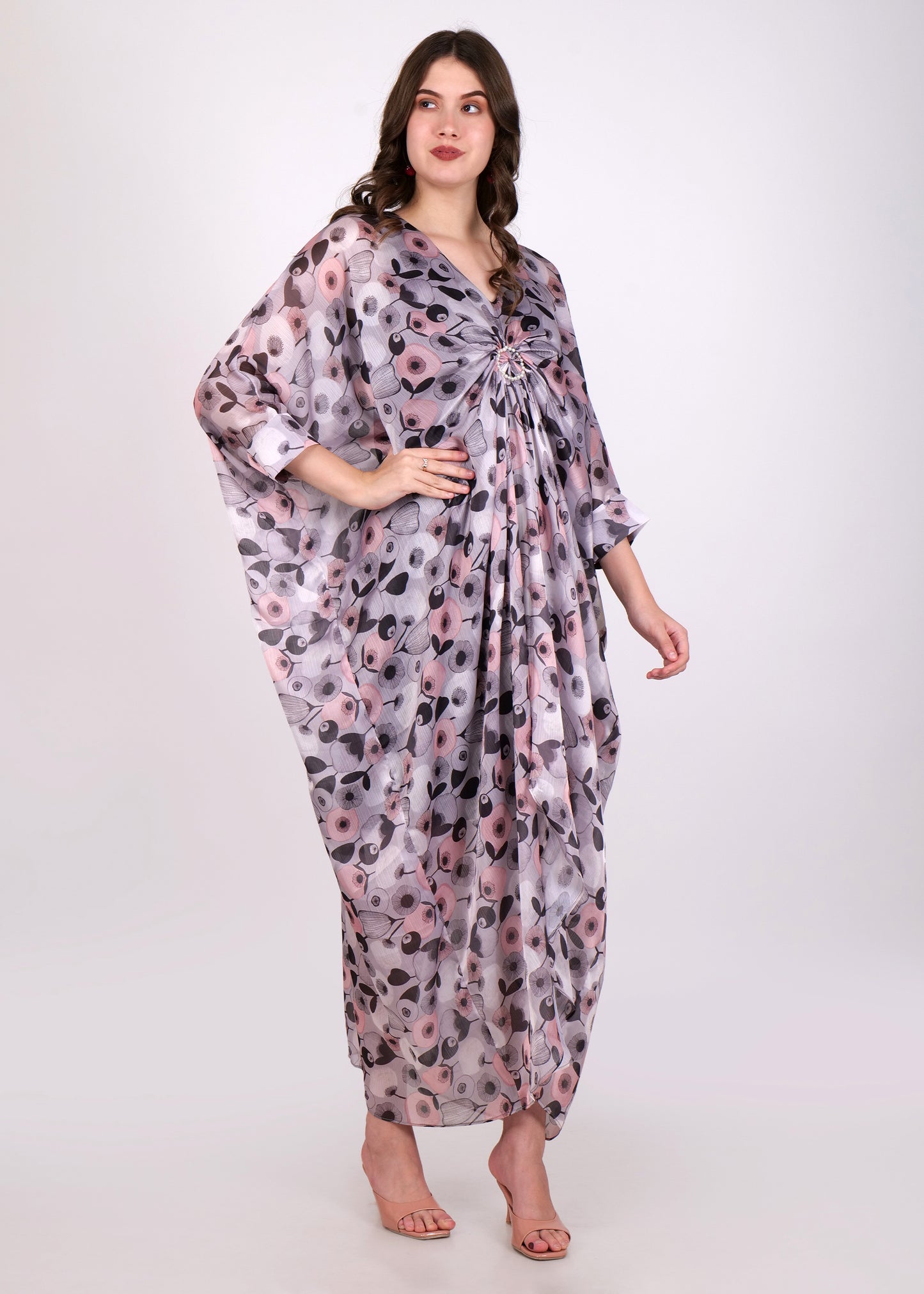 Another frontal view of the woman wearing the kaftan dress, emphasizing the loose silhouette and the intricate floral design on the lightweight fabric.