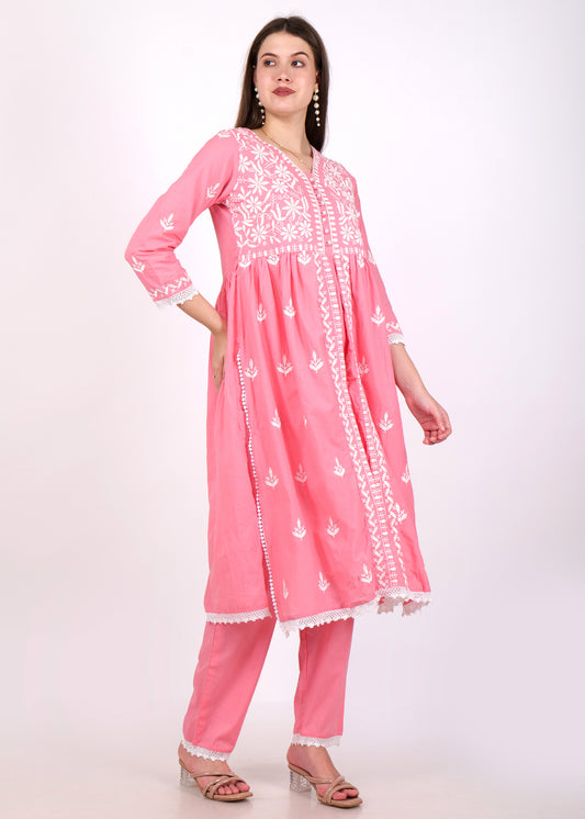 Full-length view of a woman in a pink embroidered Anarkali kurta with intricate white detailing and lace accents.