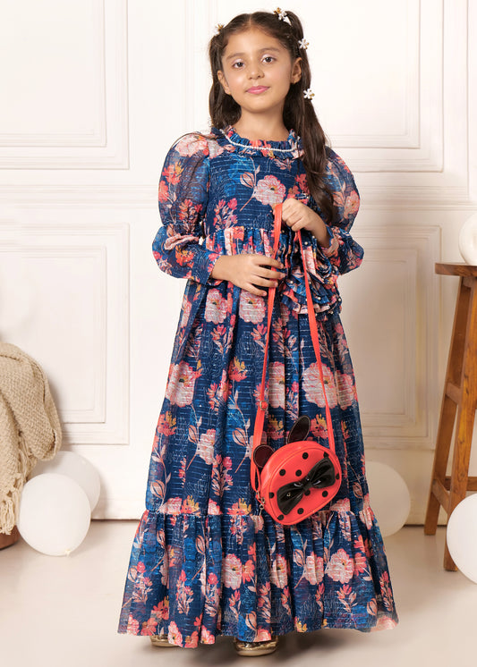 Little girl wearing a navy floral maxi dress with a large floral embellishment and puffed sleeves, holding a red ladybug purse, showcasing kids' fashion and statement accessories.