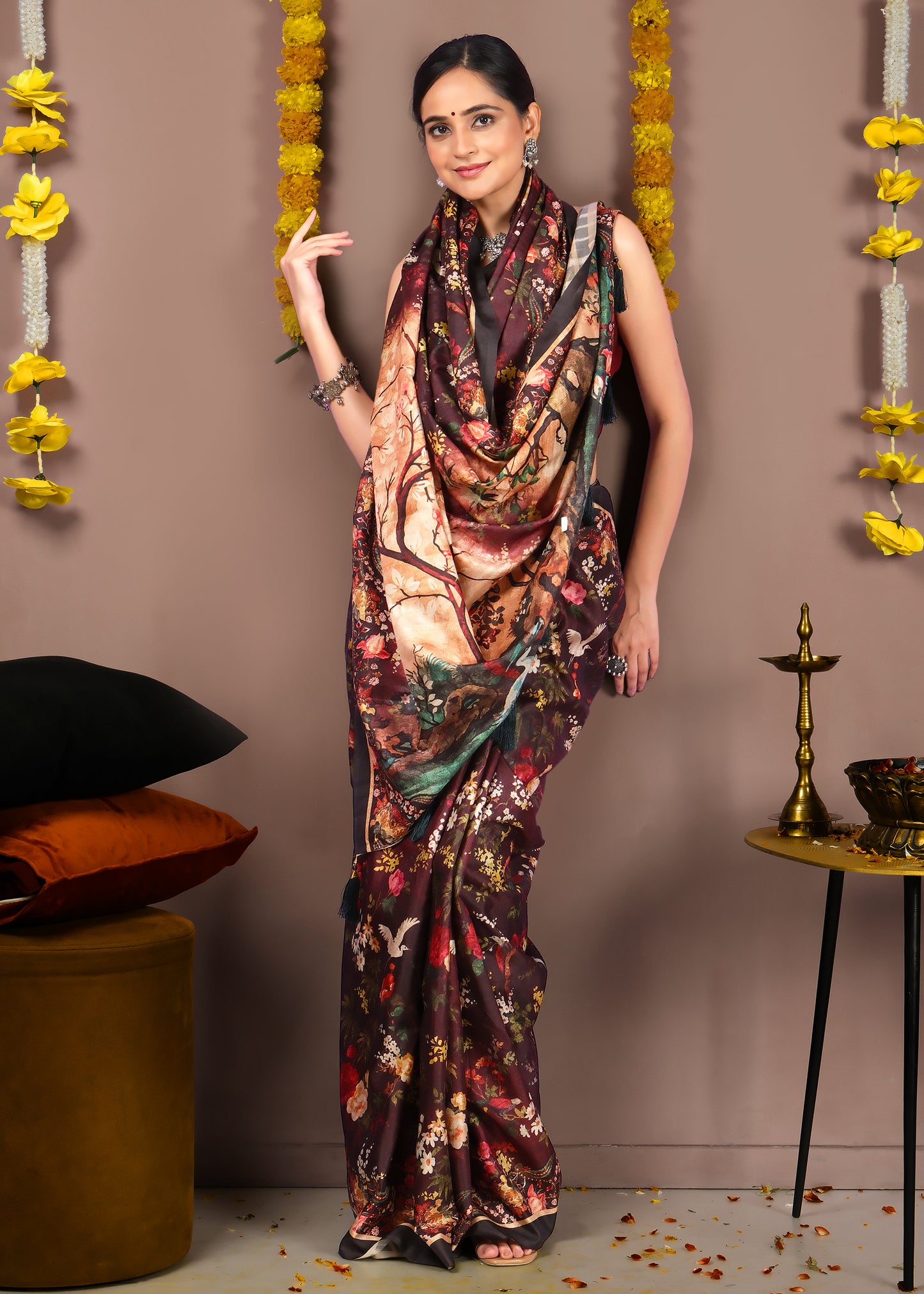 Model in a maroon saree with floral patterns and bird motifs, styled with a draped pallu, exuding grace and elegance