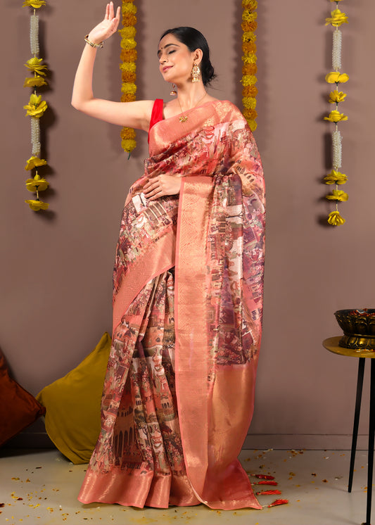 Model showcasing a peach cityscape saree with traditional Indian architecture designs on the pallu and gold accents.