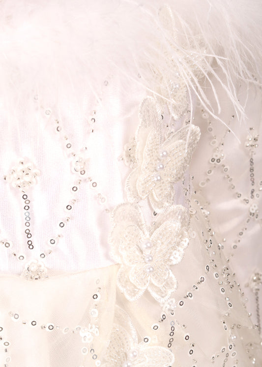 Close-up shot of the intricate butterfly and sequin embellishments on a white gown, highlighting the delicate details.