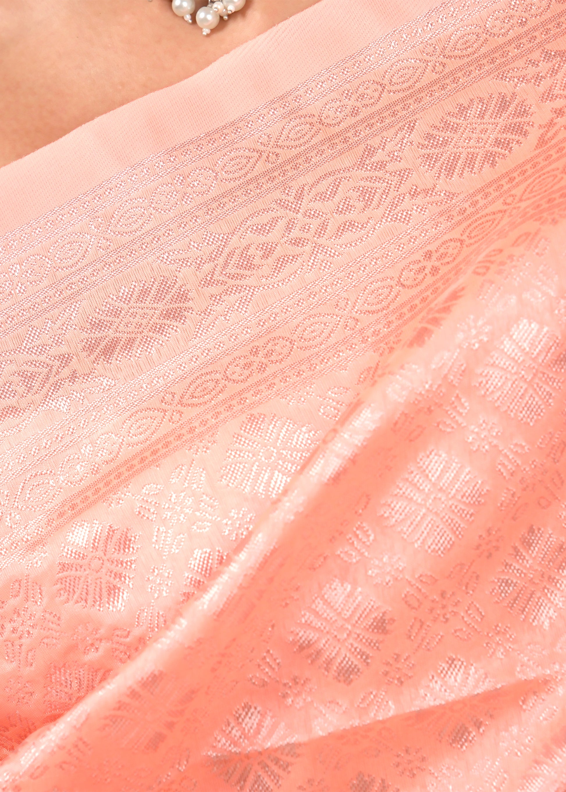 Close-up of the pink Banarasi silk saree’s intricate woven detailing, highlighting traditional craftsmanship and fine design