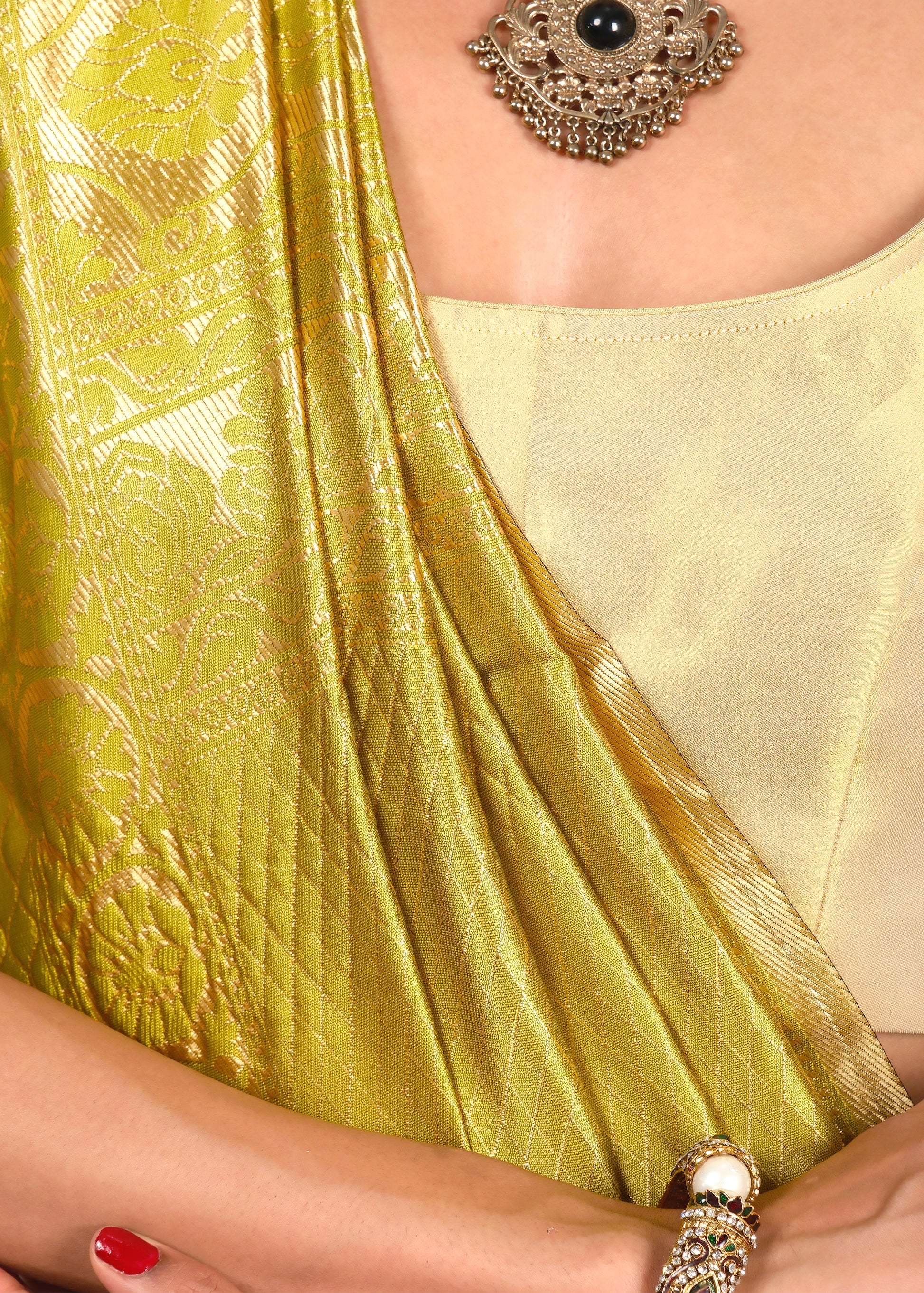 Close-up of the golden floral designs on a luxurious yellow Banarasi silk saree