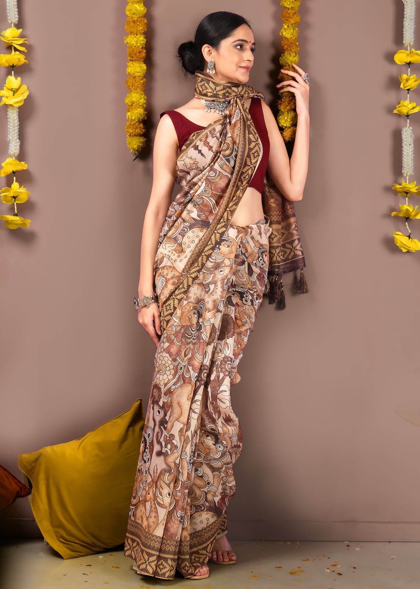 woman wearing a hand-printed saree with mythological motifs, detailed with tassels on the pallu, exuding traditional charm