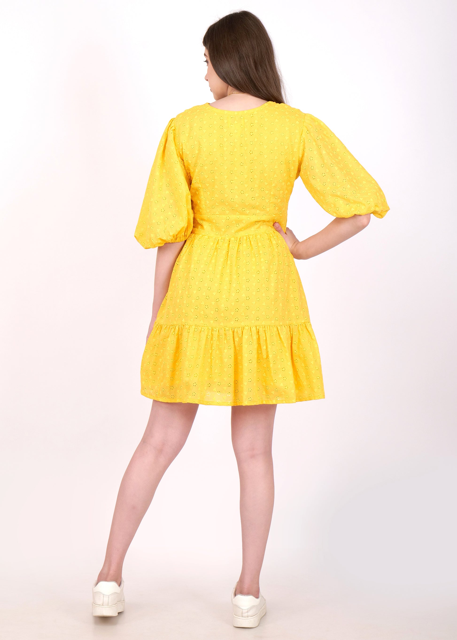 Back view of a yellow puff sleeve dress, highlighting the dress's comfortable and relaxed fit on a female model