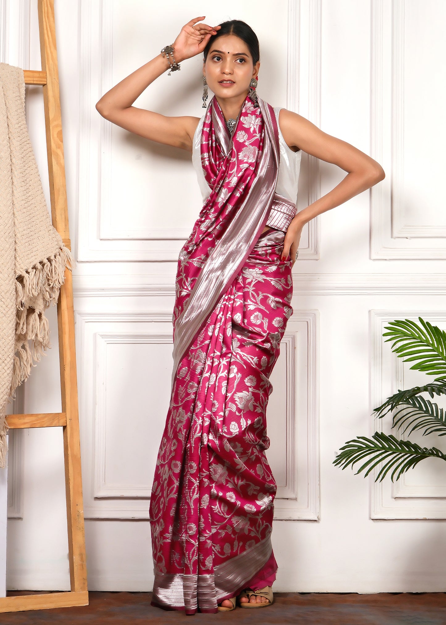 A model posing elegantly in a pink and silver Banarasi saree, emphasizing the traditional yet contemporary appeal of the design