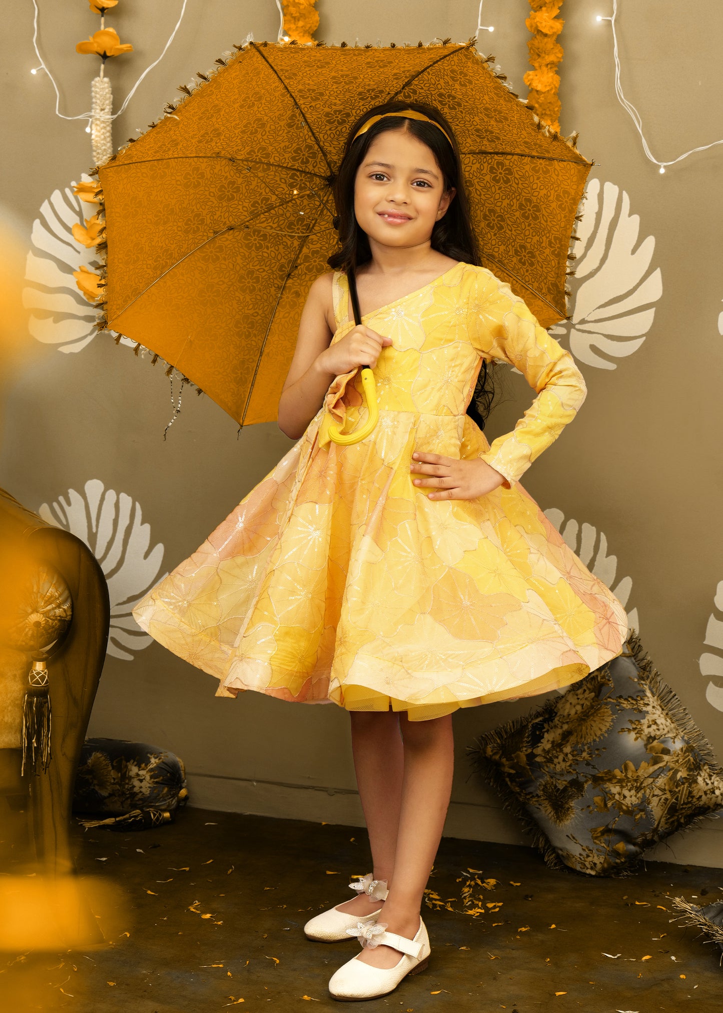 "Girl posing in a floral yellow dress, showcasing elegant design and festive-ready style."