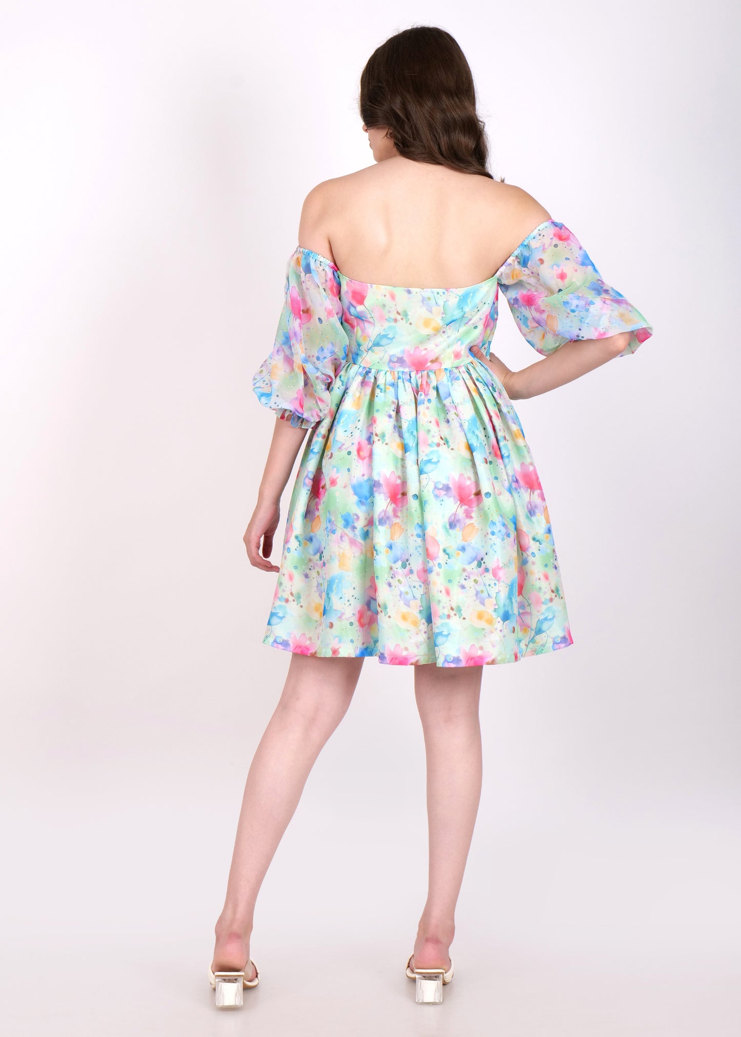 Back view of an off-shoulder pastel floral dress with a flowing silhouette