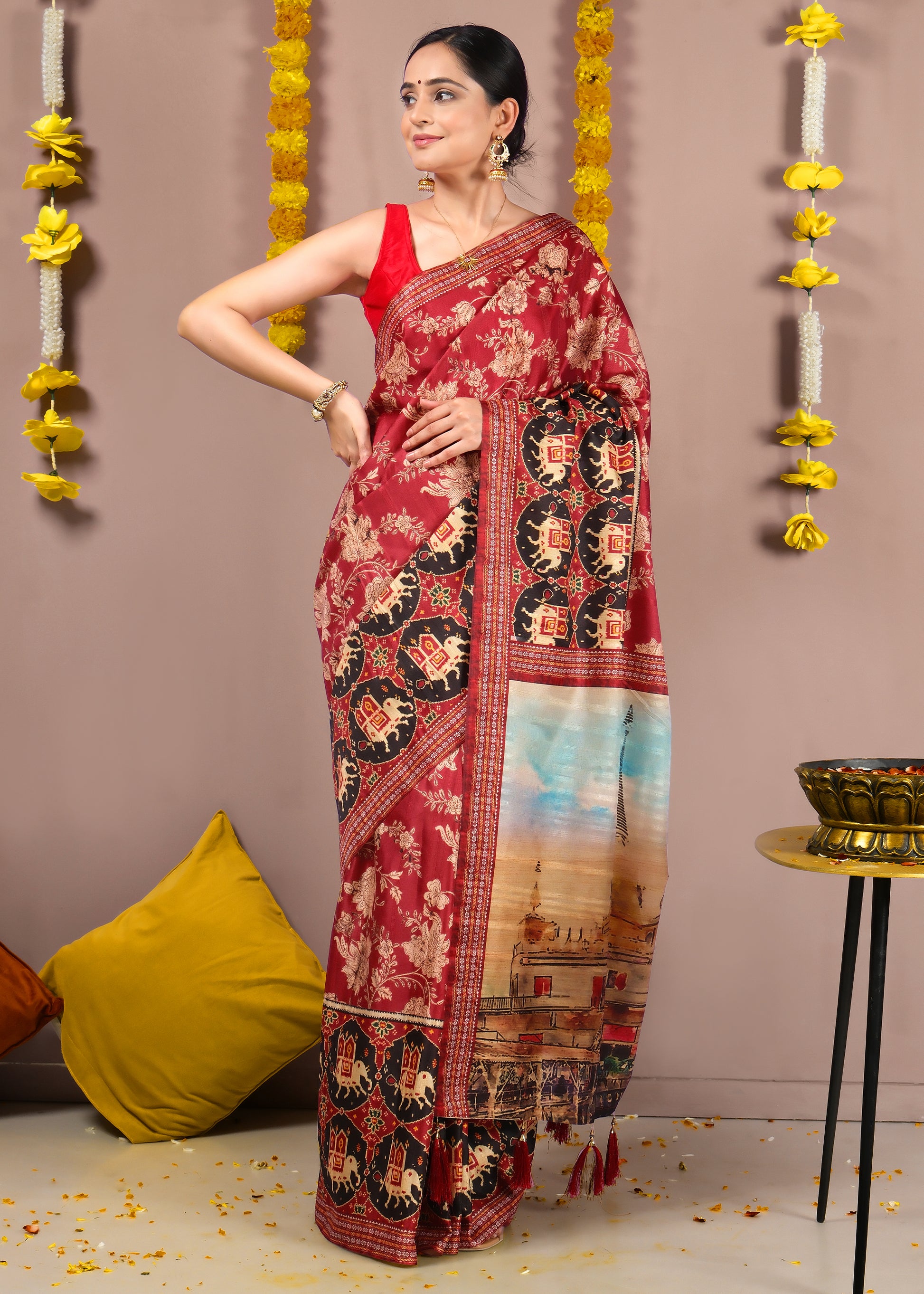  Woman posing in a red saree with golden floral work and temple artwork, styled with festive decorations.