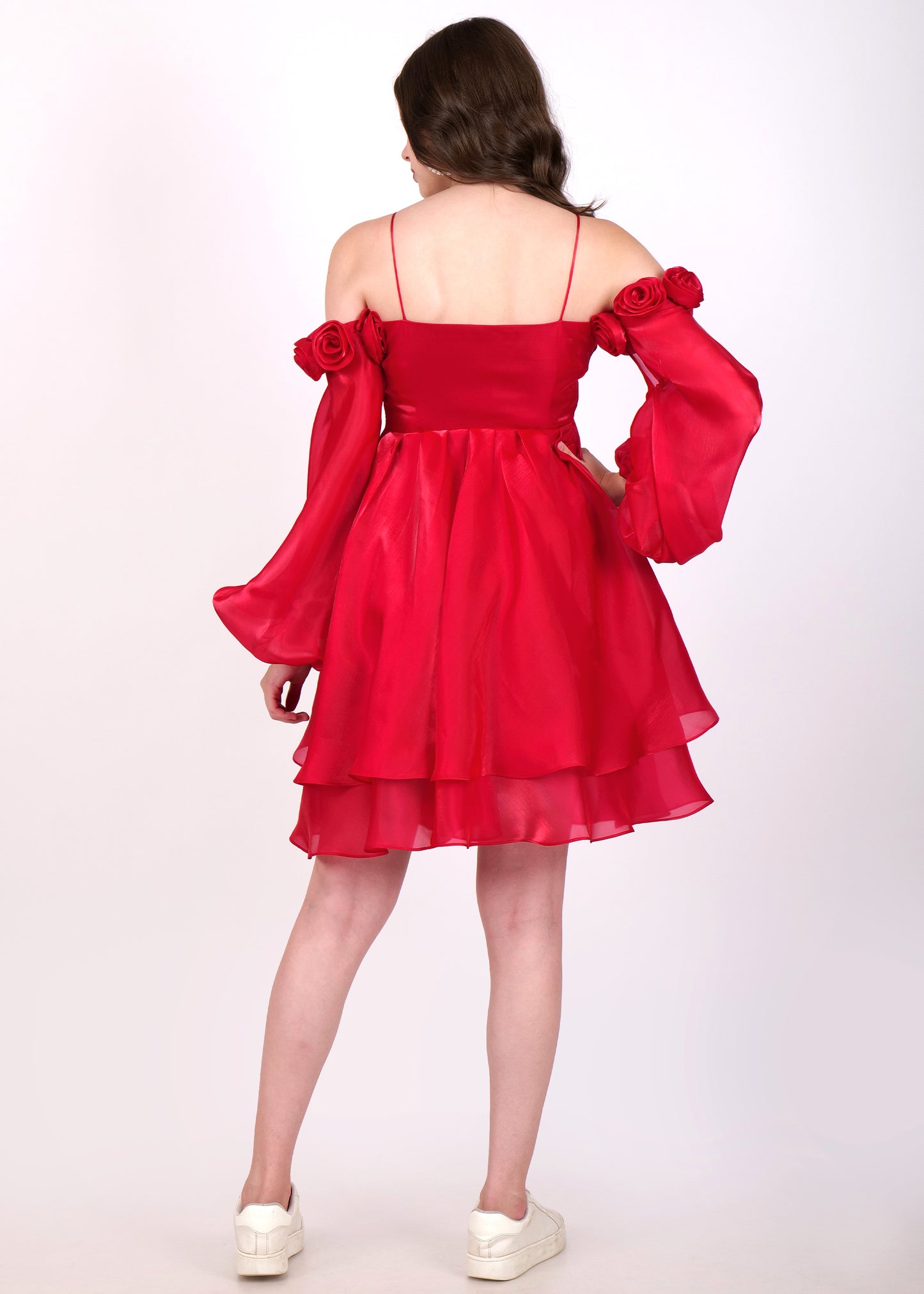 Back view of a woman wearing a red layered off-shoulder dress, highlighting the flowy skirt and delicate floral accents.