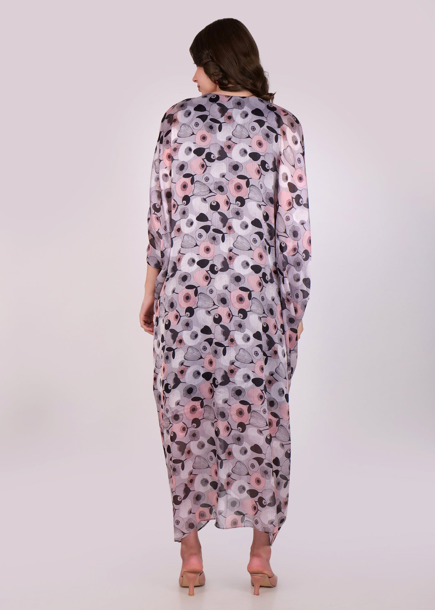 A back view of the kaftan, showcasing the all-over floral print in soft pastel tones and the long, flowing length of the dress