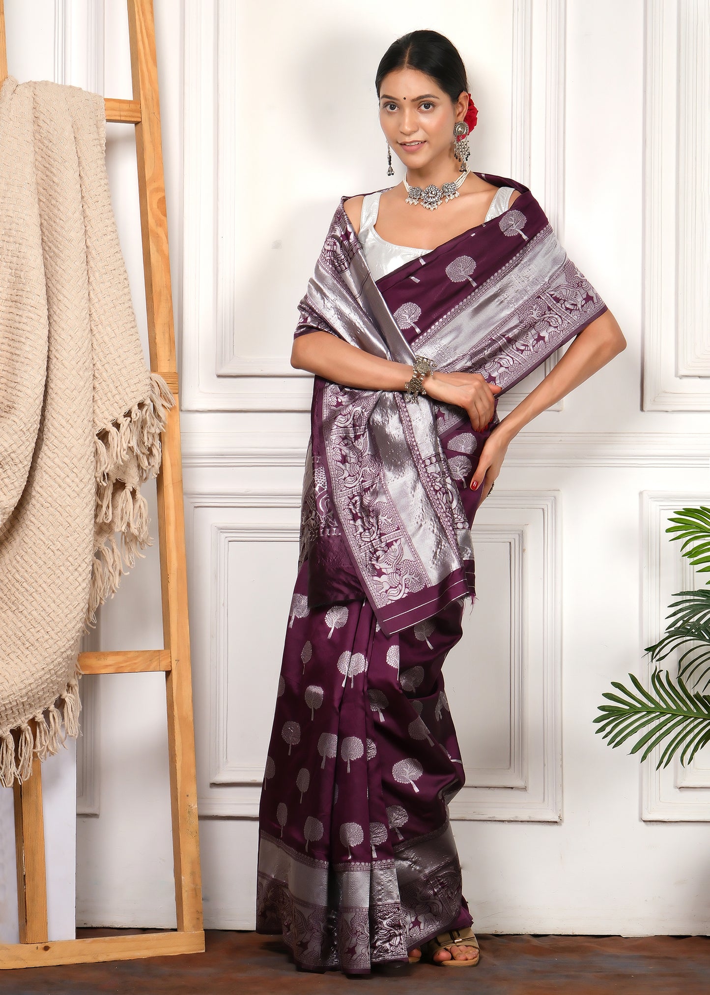 Model Wearing Purple Banarasi Saree with Silver Pallu and Traditional Jewelry
The model is wearing a stunning purple Banarasi saree with silver accents, standing against a neutral backdrop, exuding elegance with traditional silver jewelry and a floral updo.