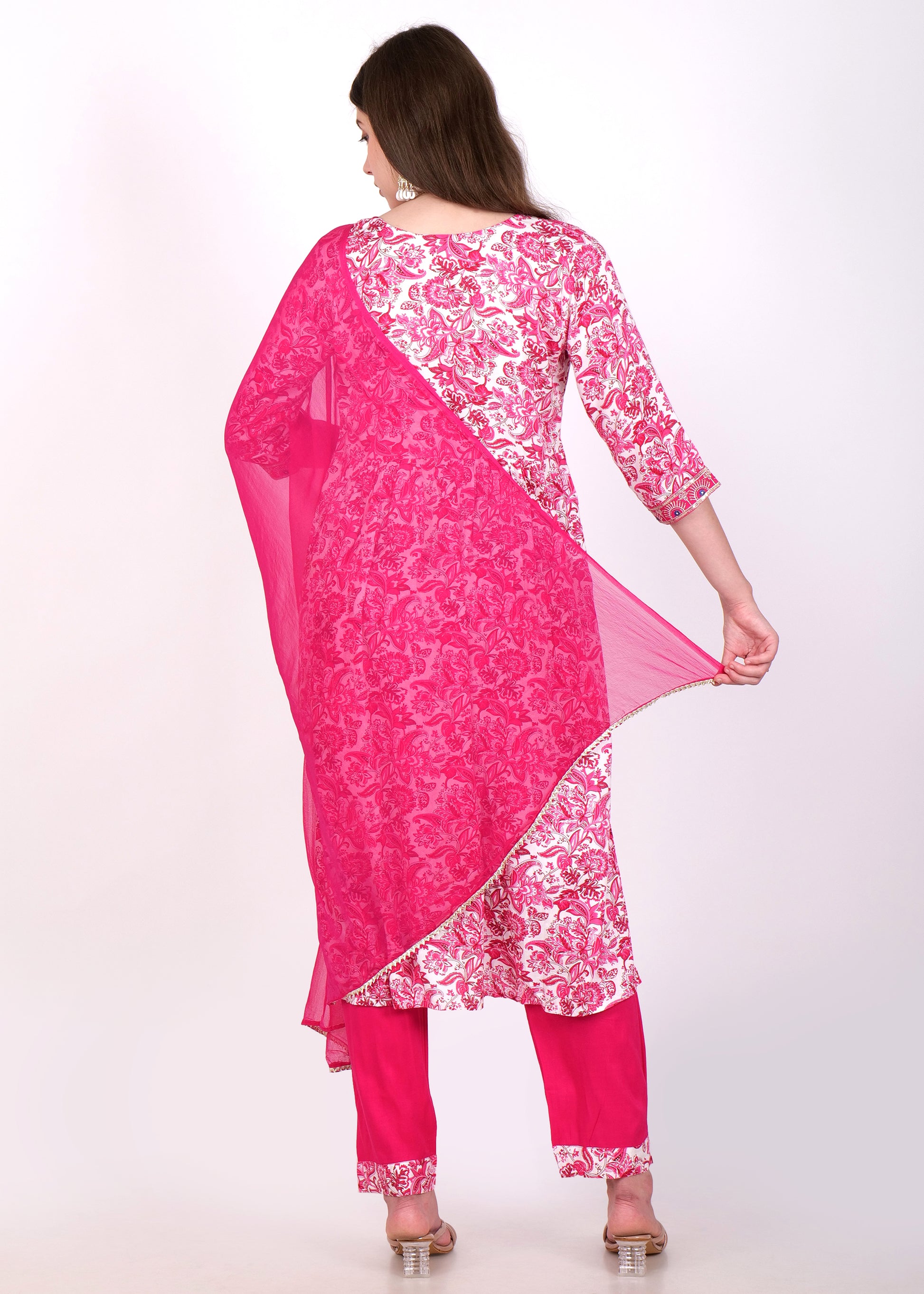 Back view of a model in a pink embroidered kurta and matching pants, holding a flowing dupatta.
