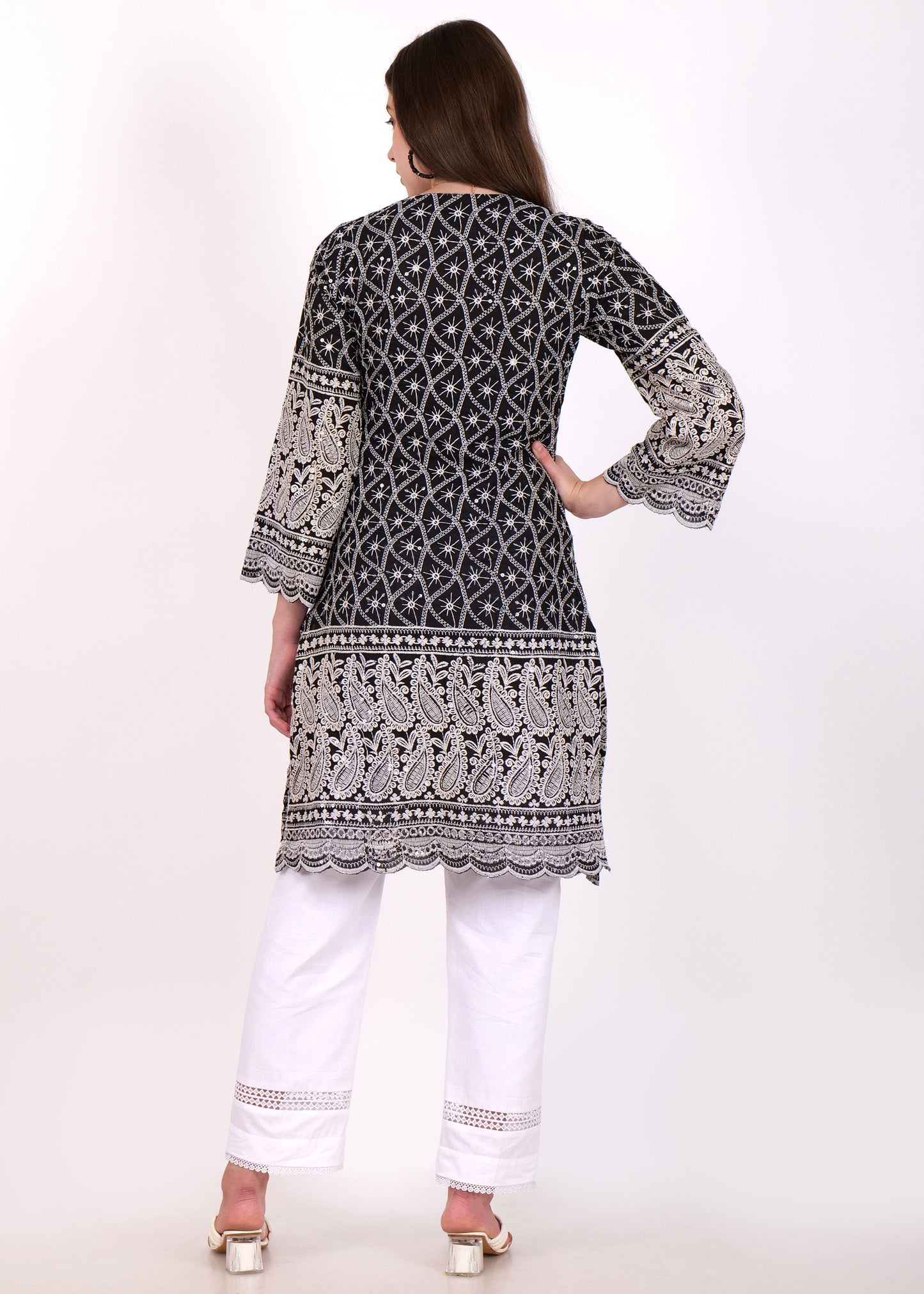Back view of a black embroidered kurta with detailed paisley patterns and paired with white ankle-length trousers