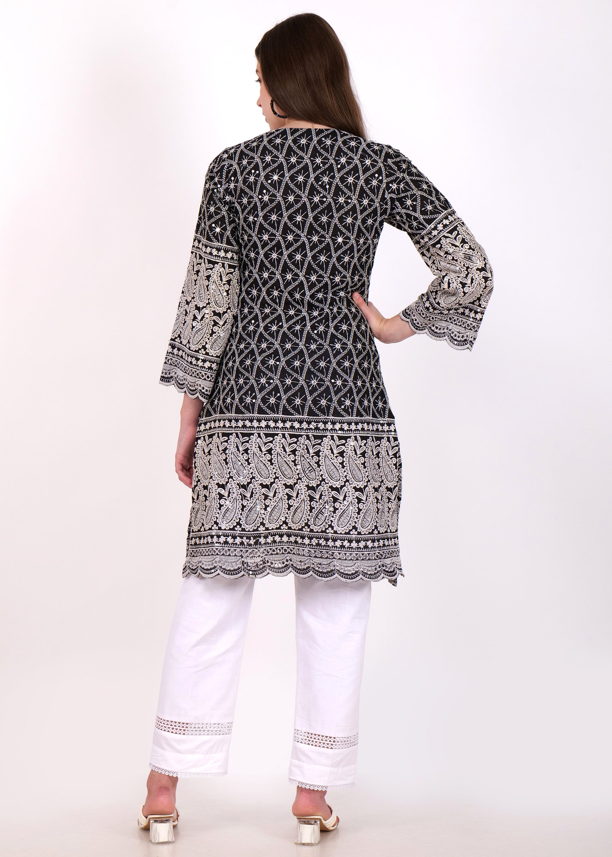 Back view of a black embroidered kurta with detailed paisley patterns and paired with white ankle-length trousers