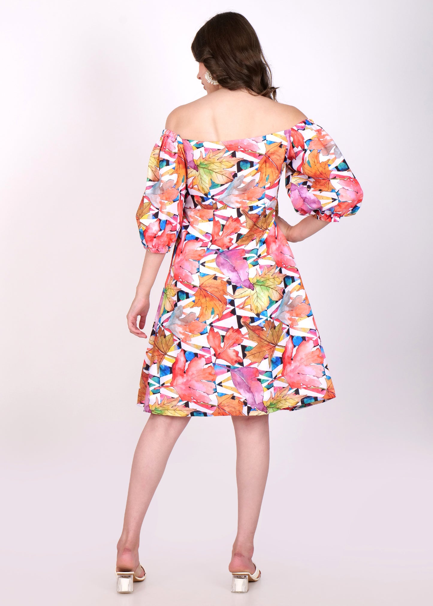 A back view of the dress, highlighting the off-shoulder style and how the floral leaf design wraps around the entire garment