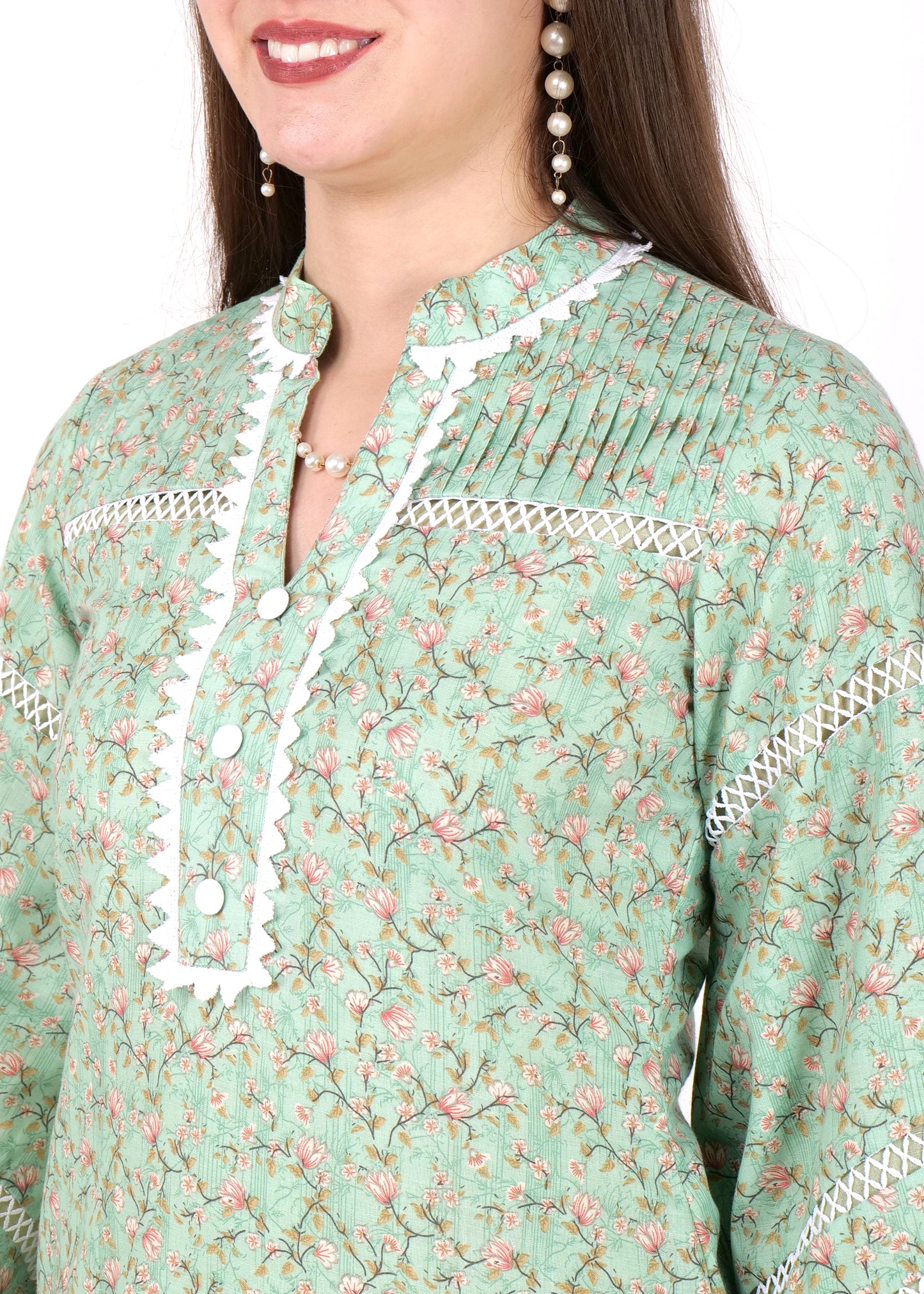 Close-up of the floral fabric and lace neckline on a green kurta, highlighting the detailed stitching and floral pattern.