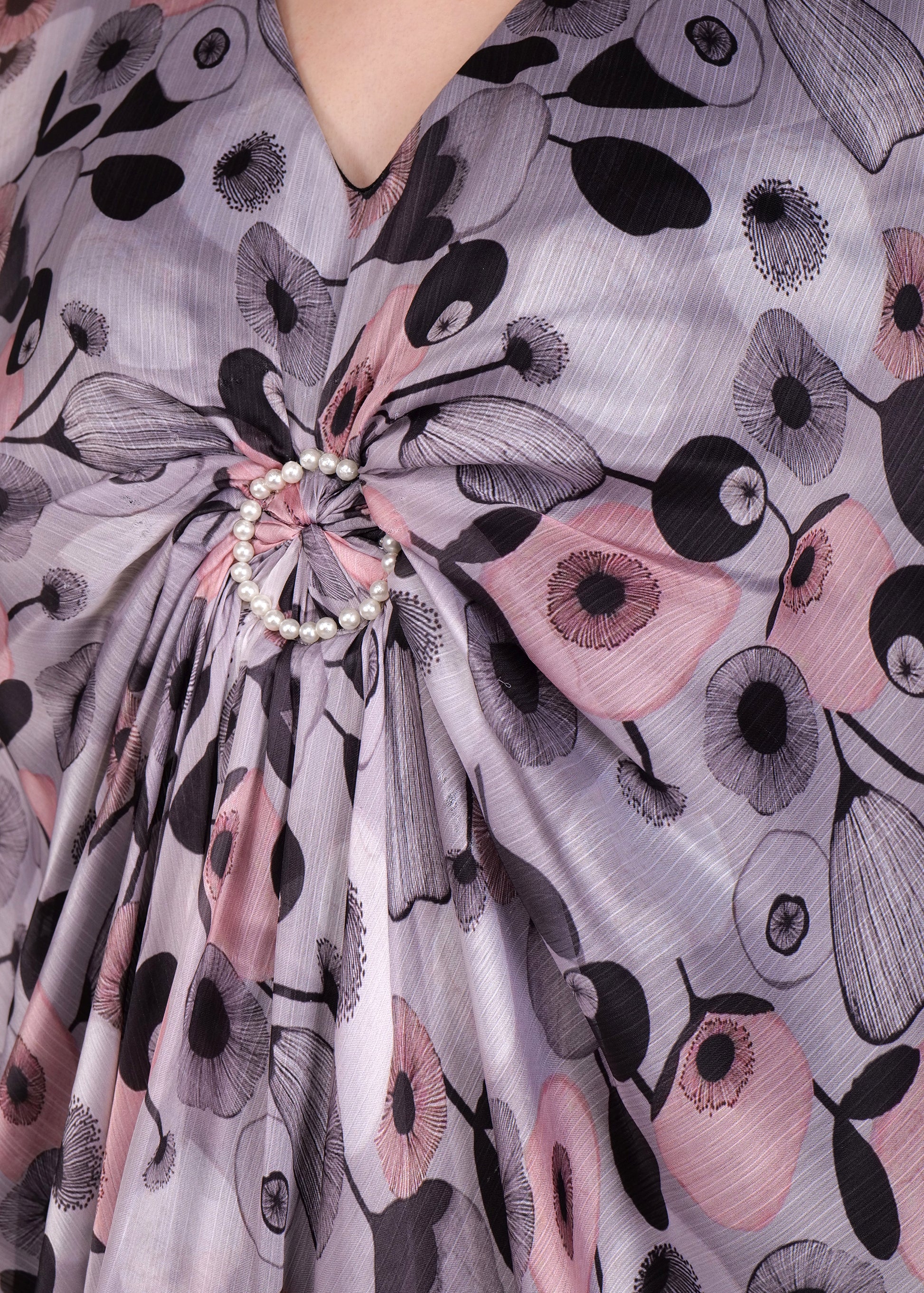 A back view of the kaftan, showcasing the all-over floral print in soft pastel tones and the long, flowing length of the dress