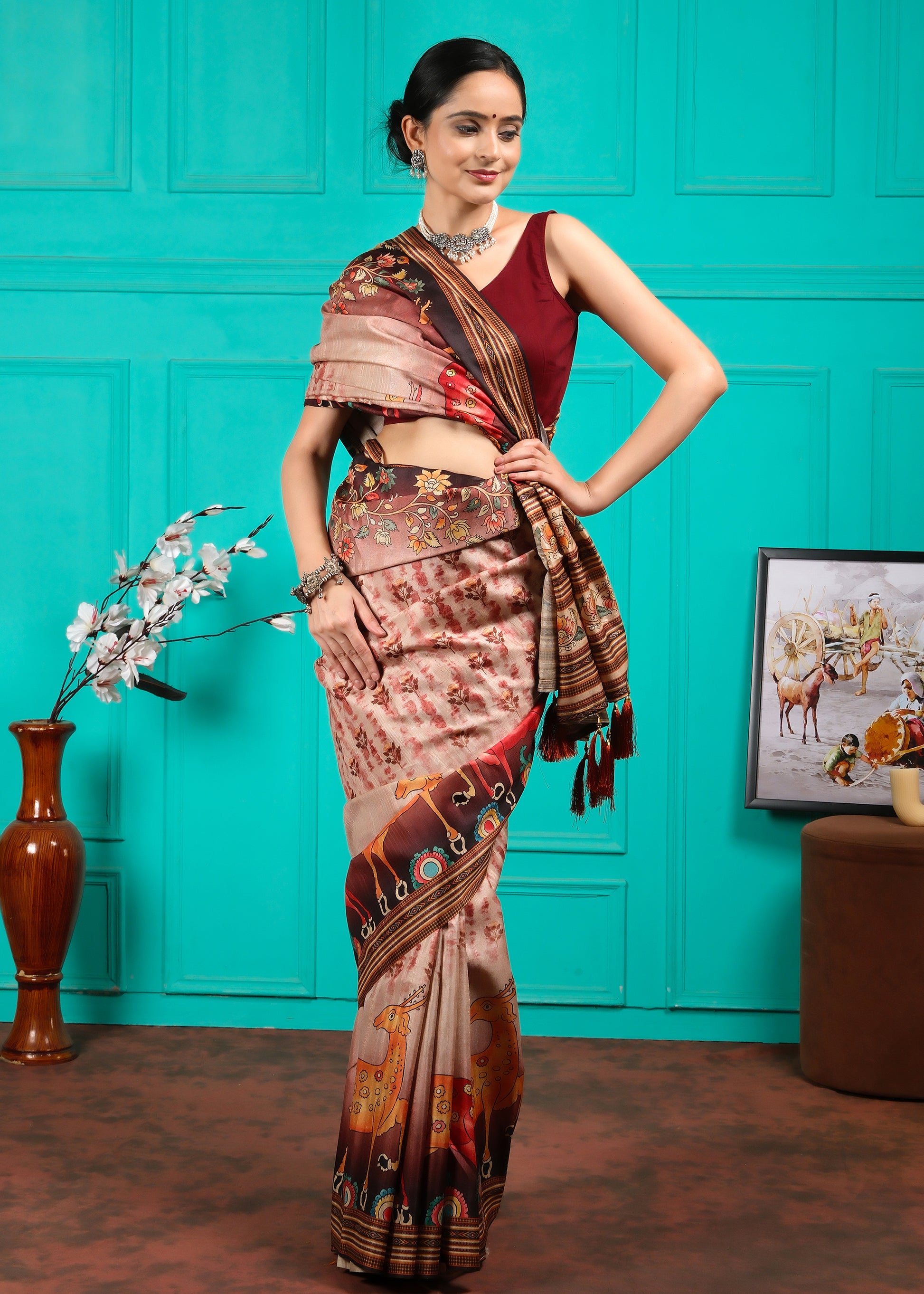 Model in beige saree with maroon blouse, styled with detailed floral and animal motif pallu