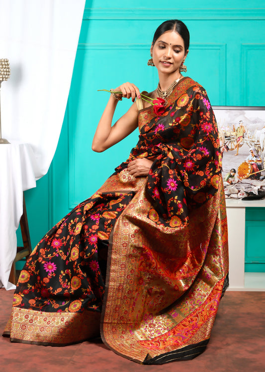 Model holding a rose in a vibrant black and gold Banarasi silk saree, showcasing traditional Indian bridal elegance.