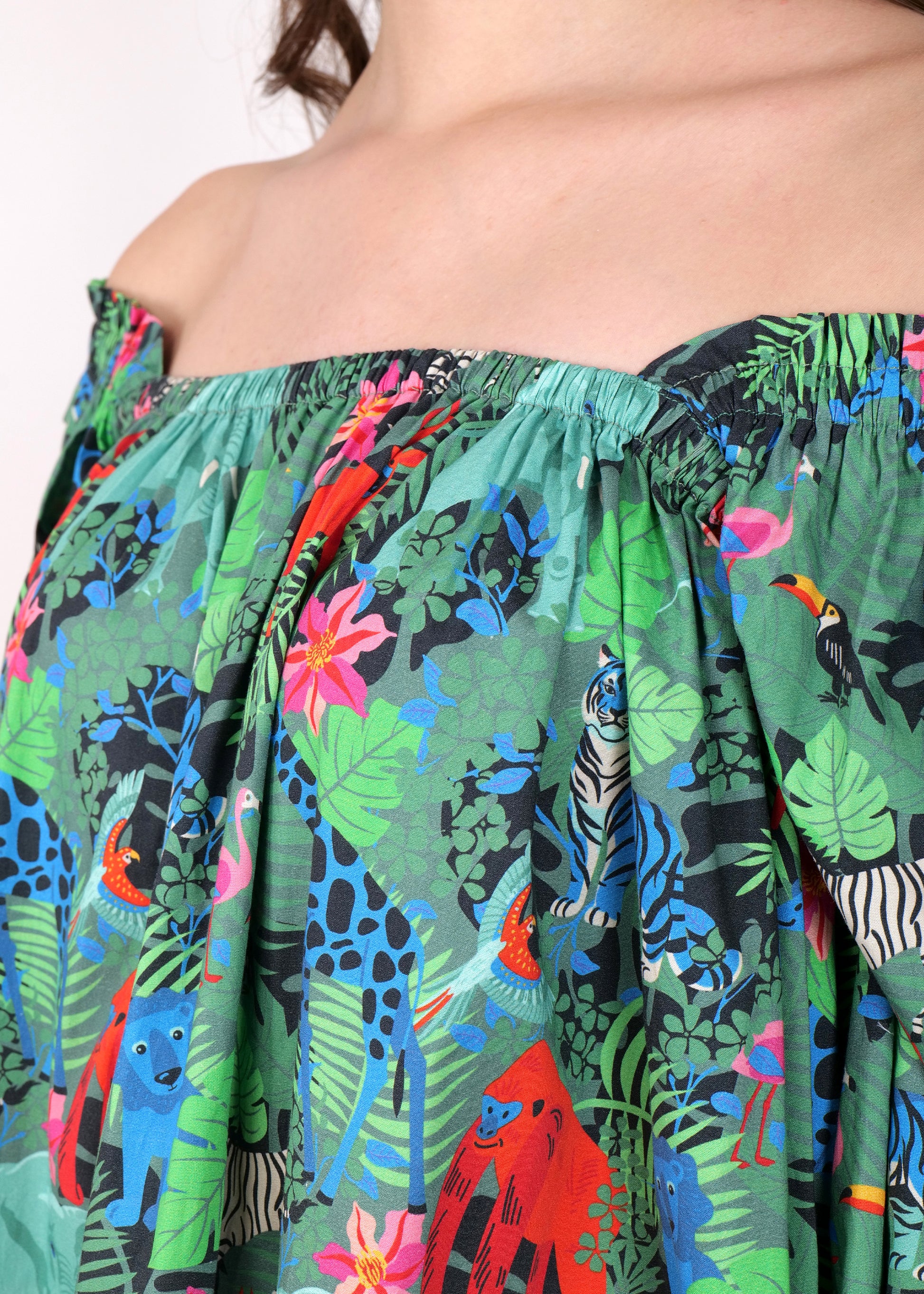 Close-up of jungle-inspired animal print fabric on a trendy off-shoulder dress, highlighting the detailed pattern