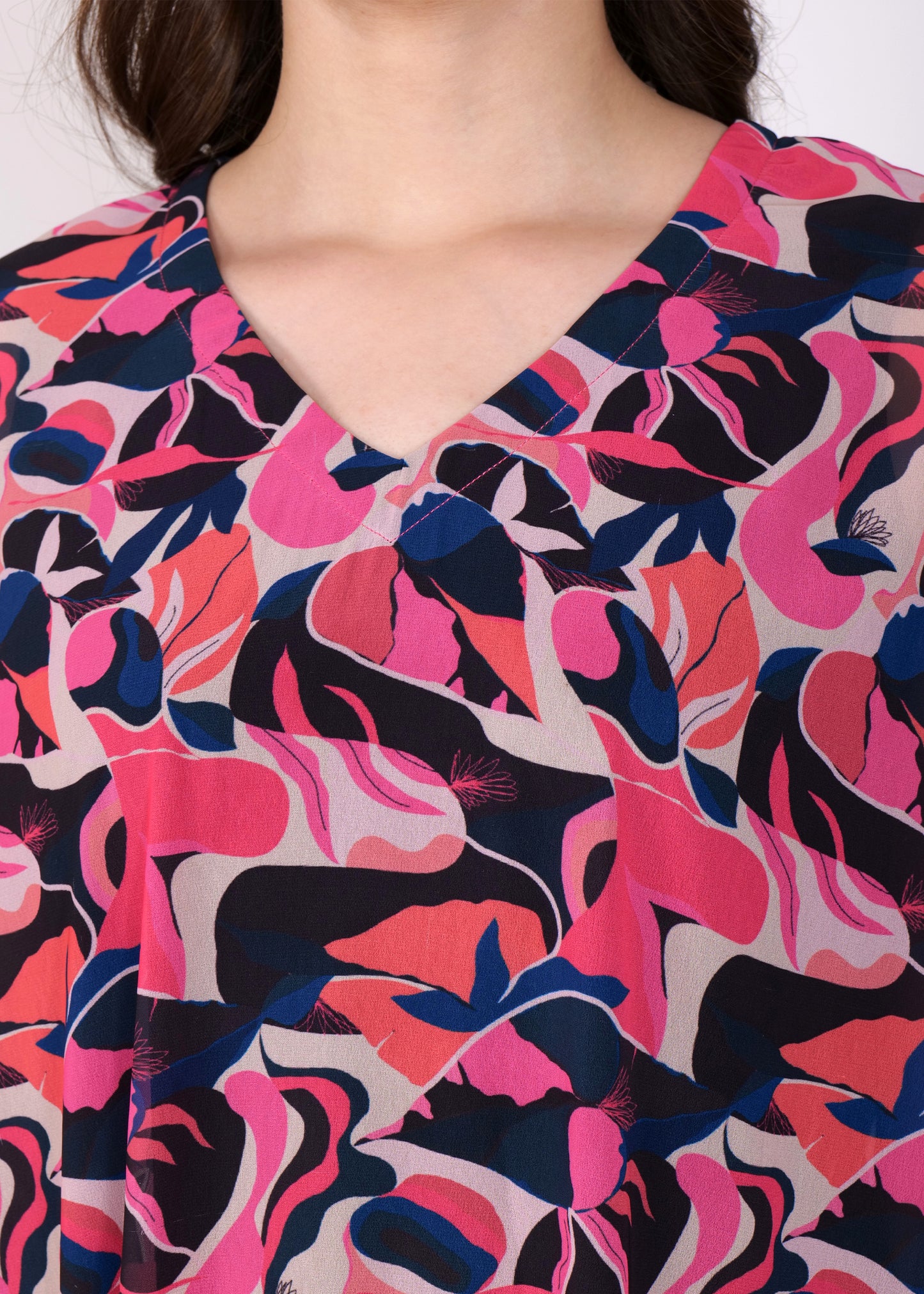 Close-up of the pink and purple abstract print fabric on a kaftan dress, featuring intricate detail and bold color