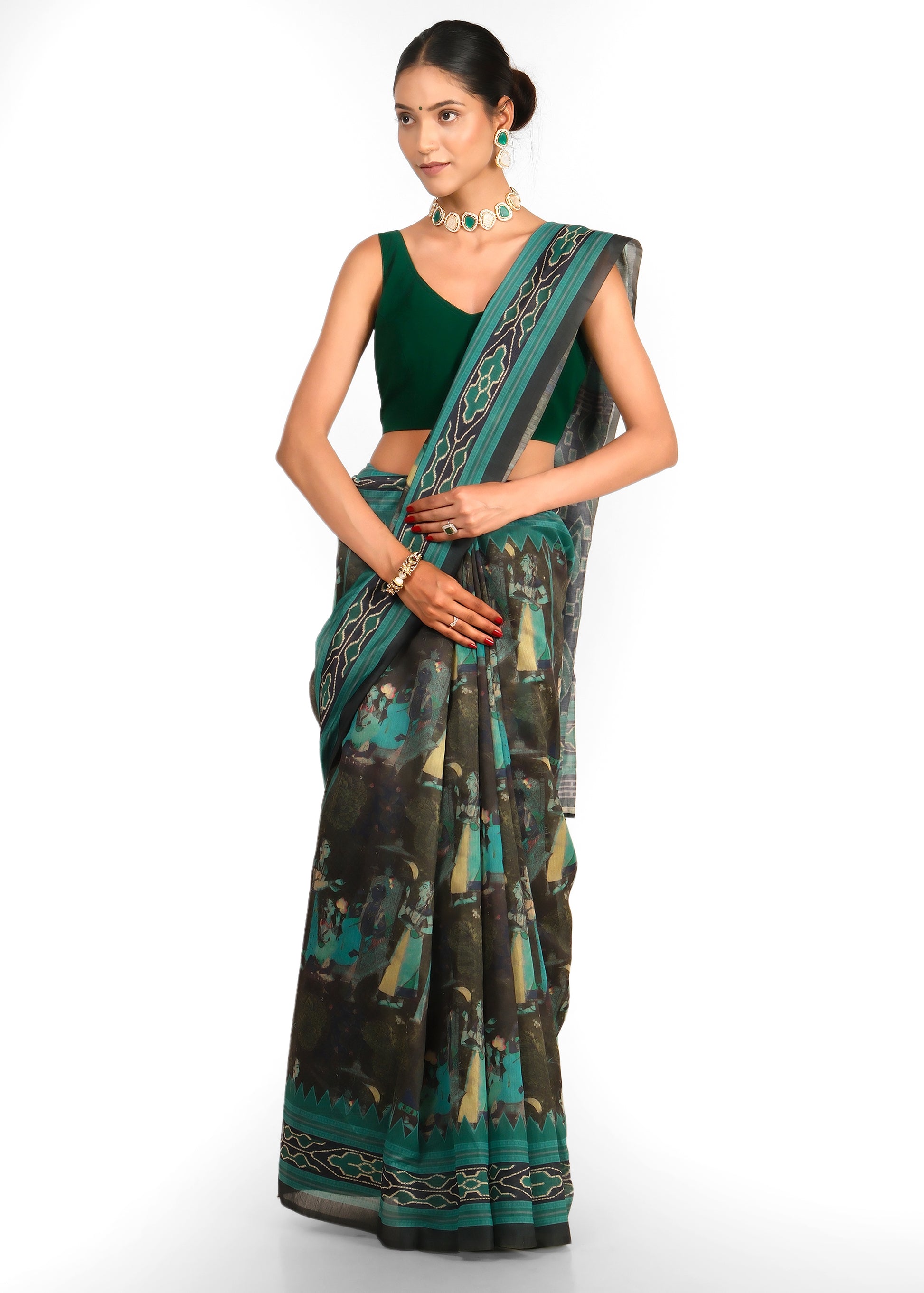 Model posing in a green saree with a patterned black border, showing the back of her blouse and drape