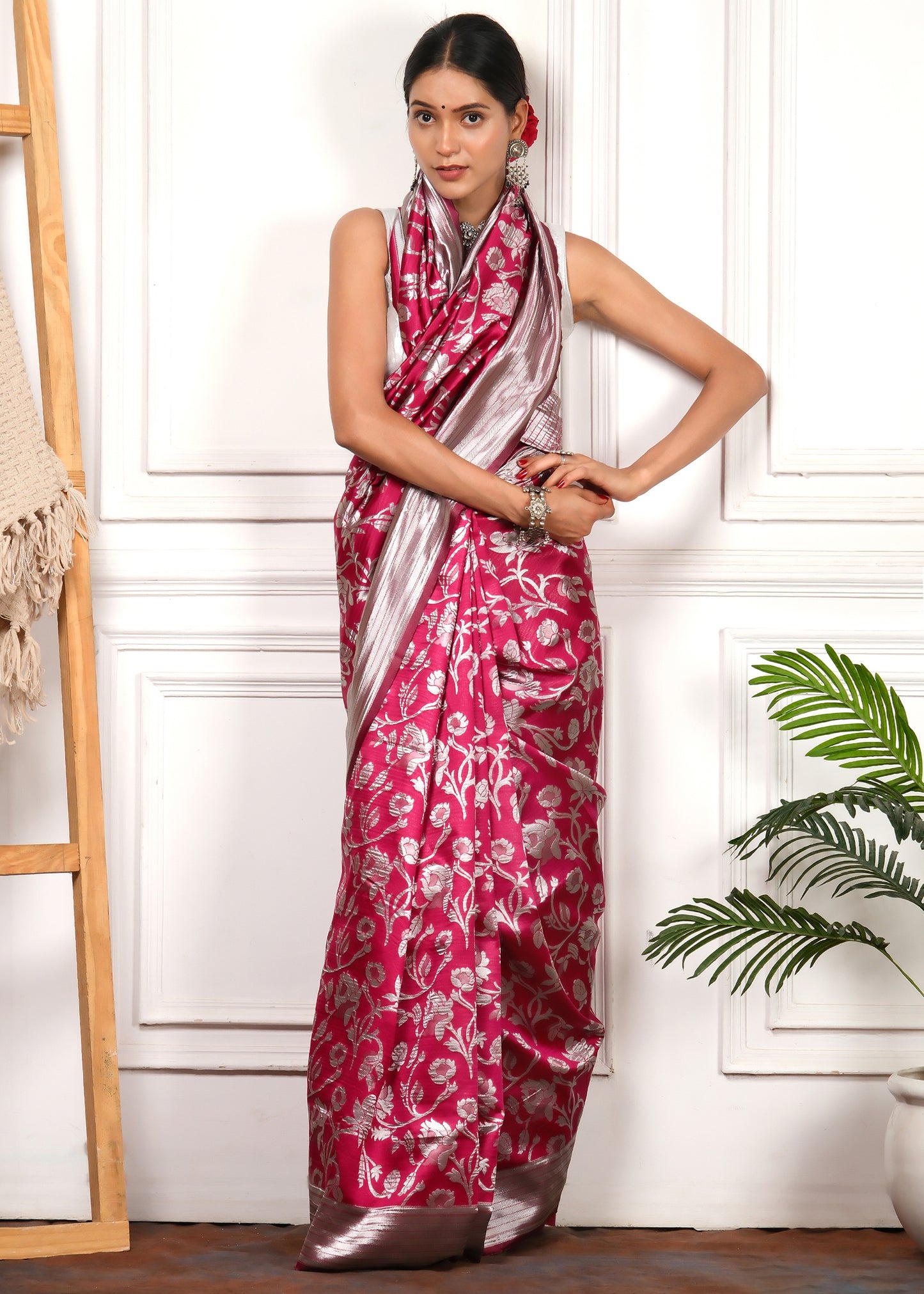 A model flaunting the delicate drape of a pink and silver Banarasi silk saree with intricate woven motifs and contrasting border.