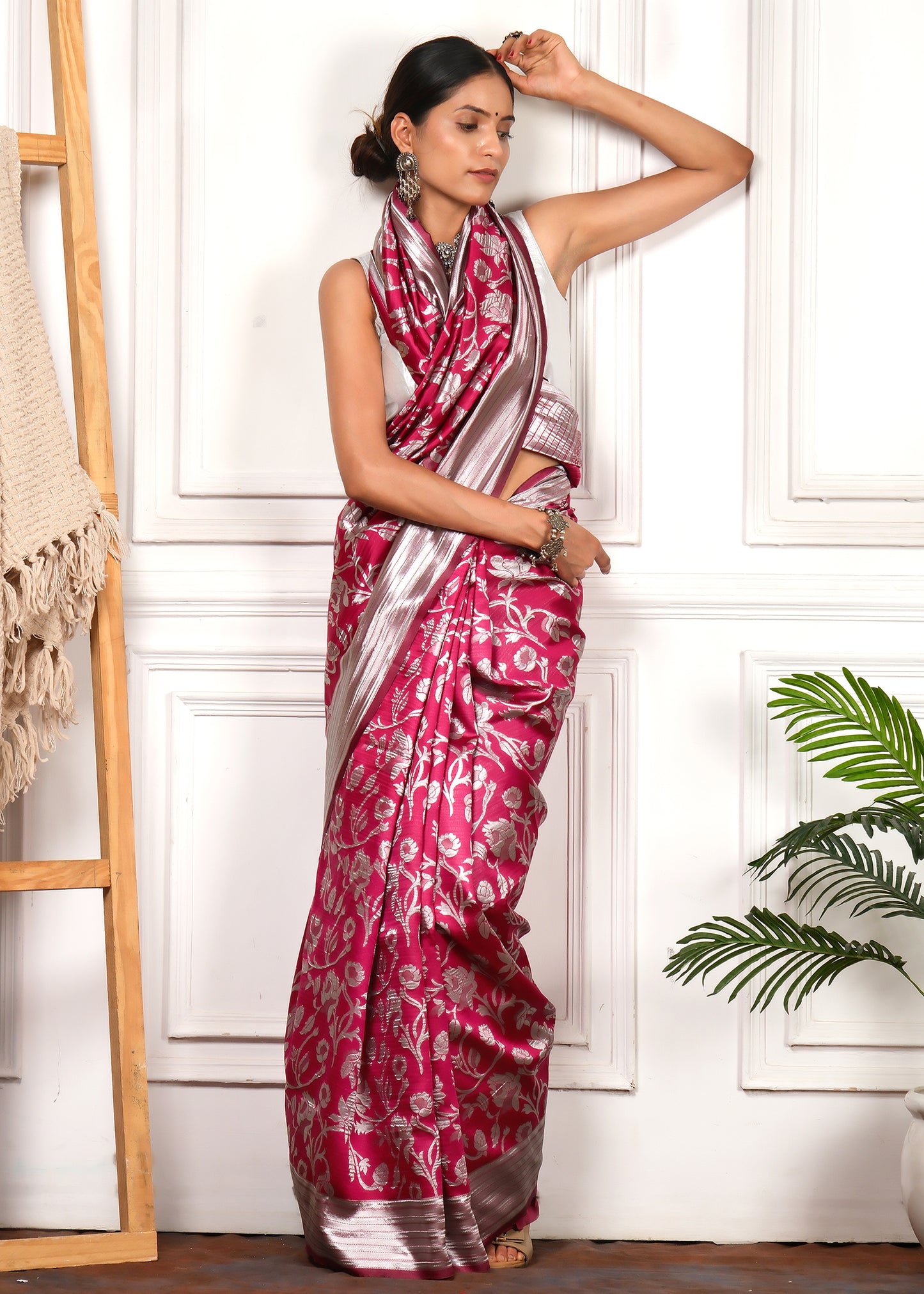 A model exuding grace while posing in a pink and silver Banarasi silk saree, adorned with ornate silver jewelry for a perfect festive look